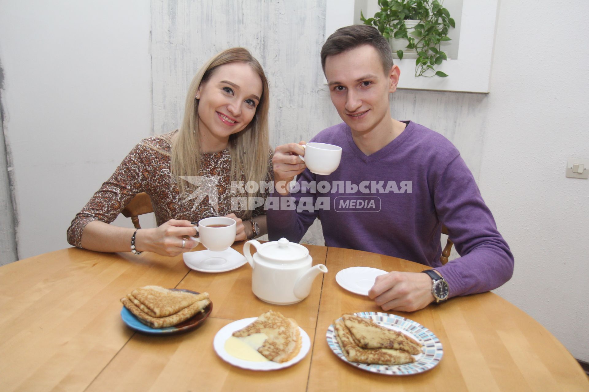 Иркутск. Молодой человек и девушка пьют чай с блинами.