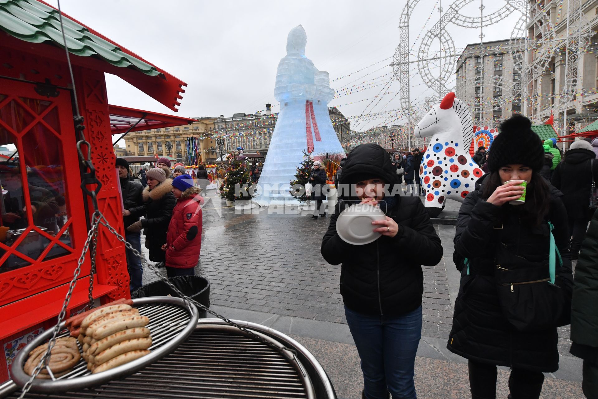 Москва. Участники фестиваля `Московская Масленица`  едят блины на Манежной площади.