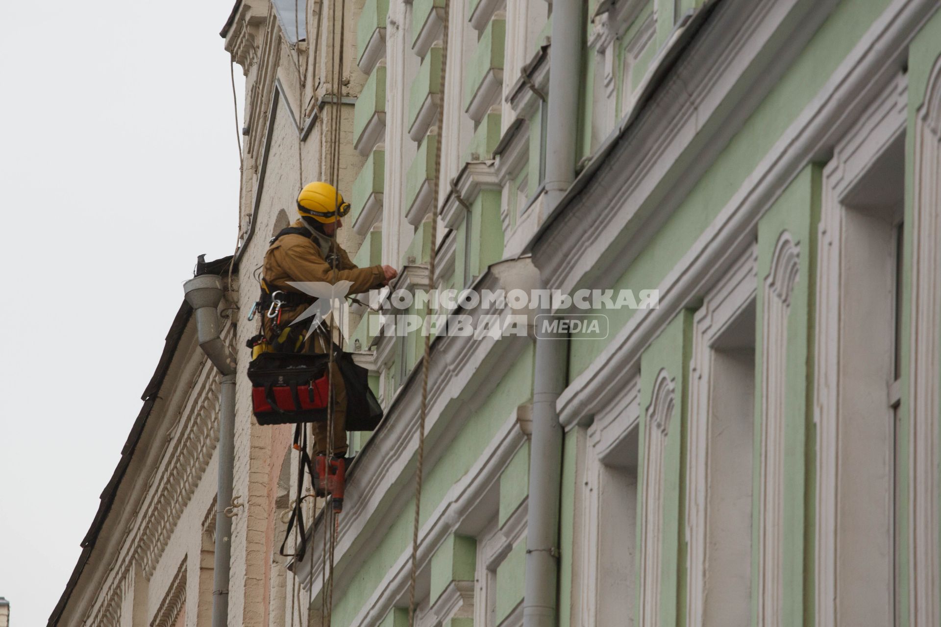 Москва. Промышленный альпинист ремонтирует фасад здания.