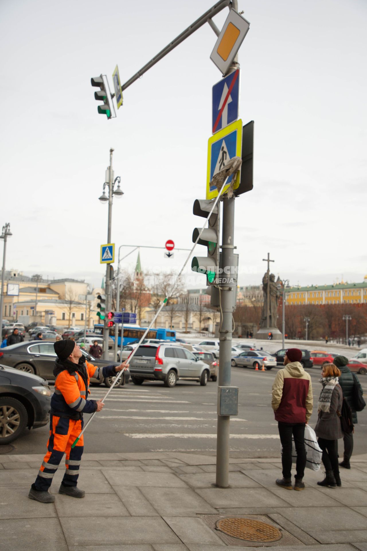 Москва. Сотрудник коммунальной службы моет дорожный знак на одной из улиц города.