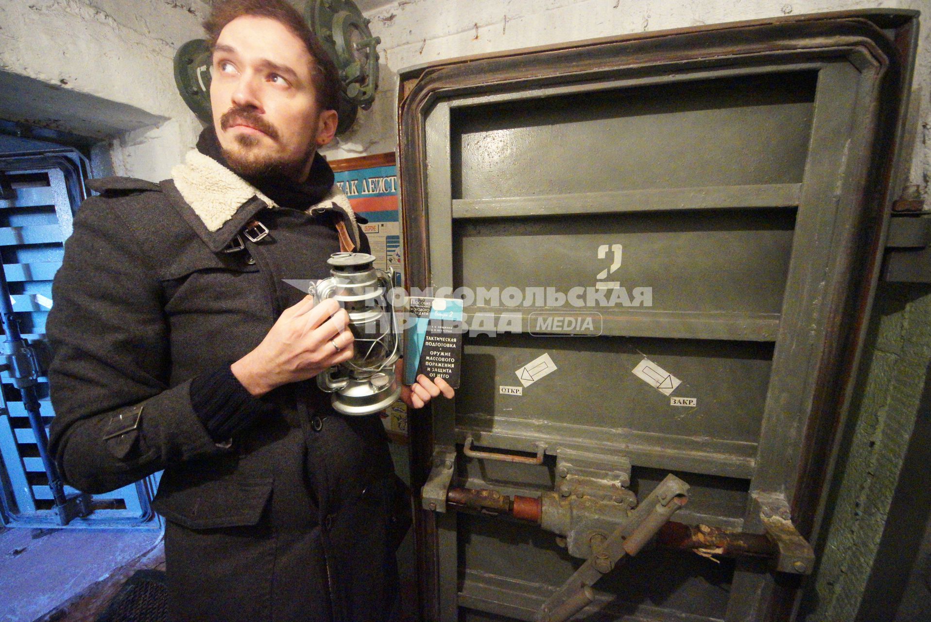 Екатеринбург. Мужчина с книгой о оружии массового поражения и керосиновой лампой у дверей убежища