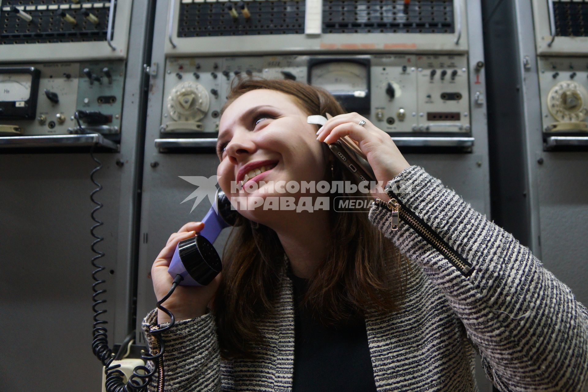 Екатеринбург. Девушка с мобильным телефоном и телефонной трубкой аналоговой телефонной станции \'Ростелеком\'