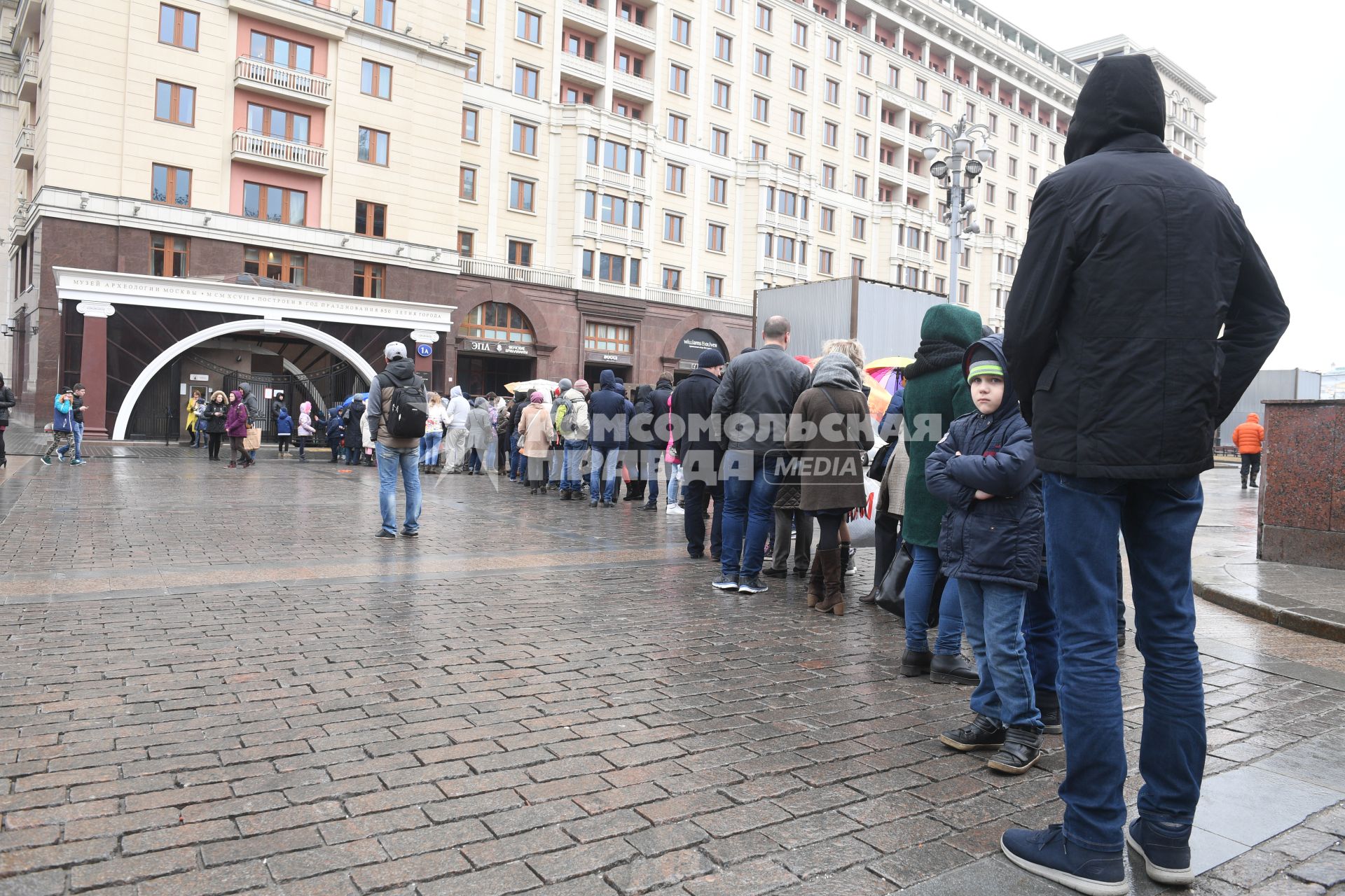 Москва.  Посетители стоят в очереди в музей археологии Москвы на Манежной площади.