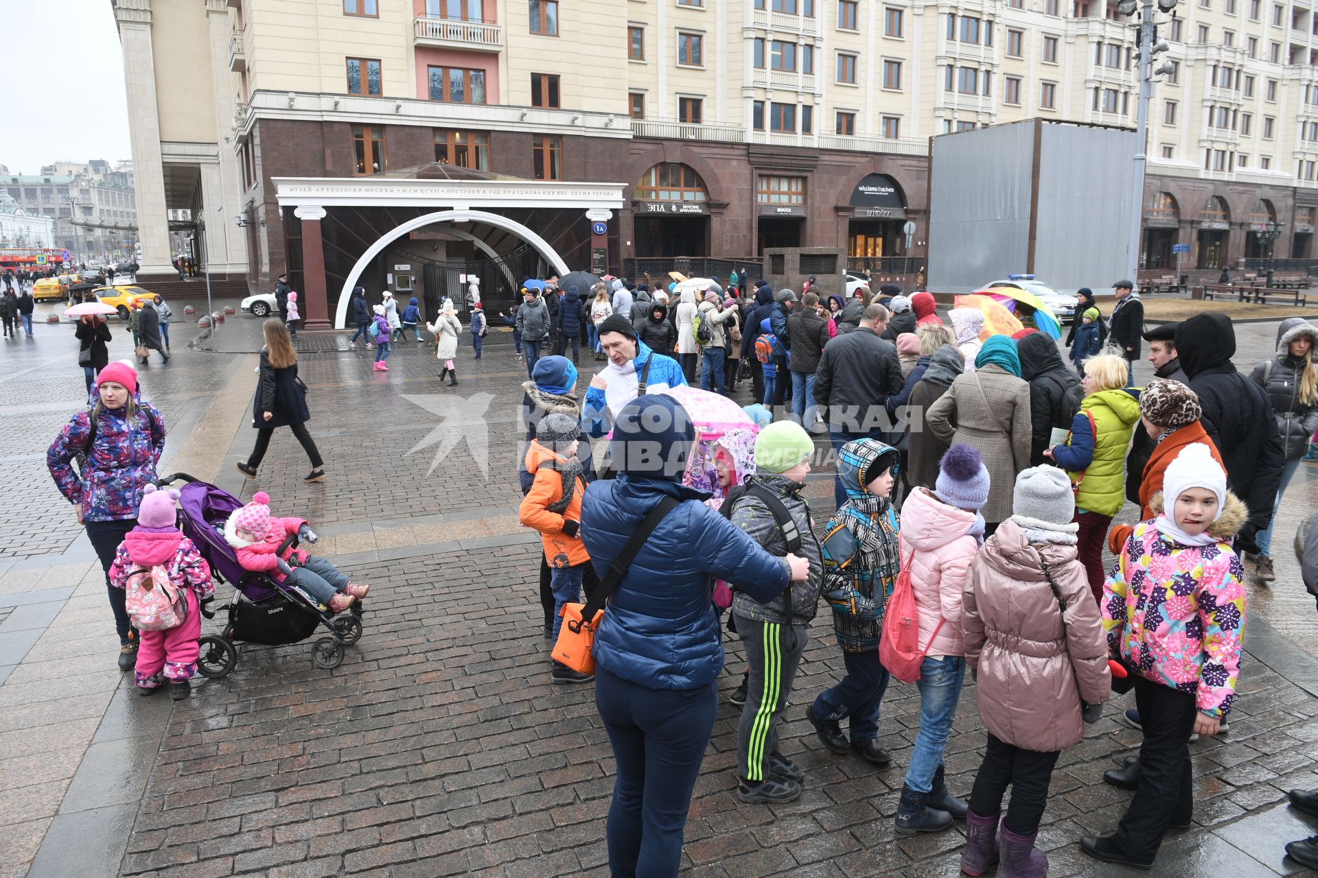 Москва.   Дети стоят в очереди в музей археологии Москвы на Манежной площади.