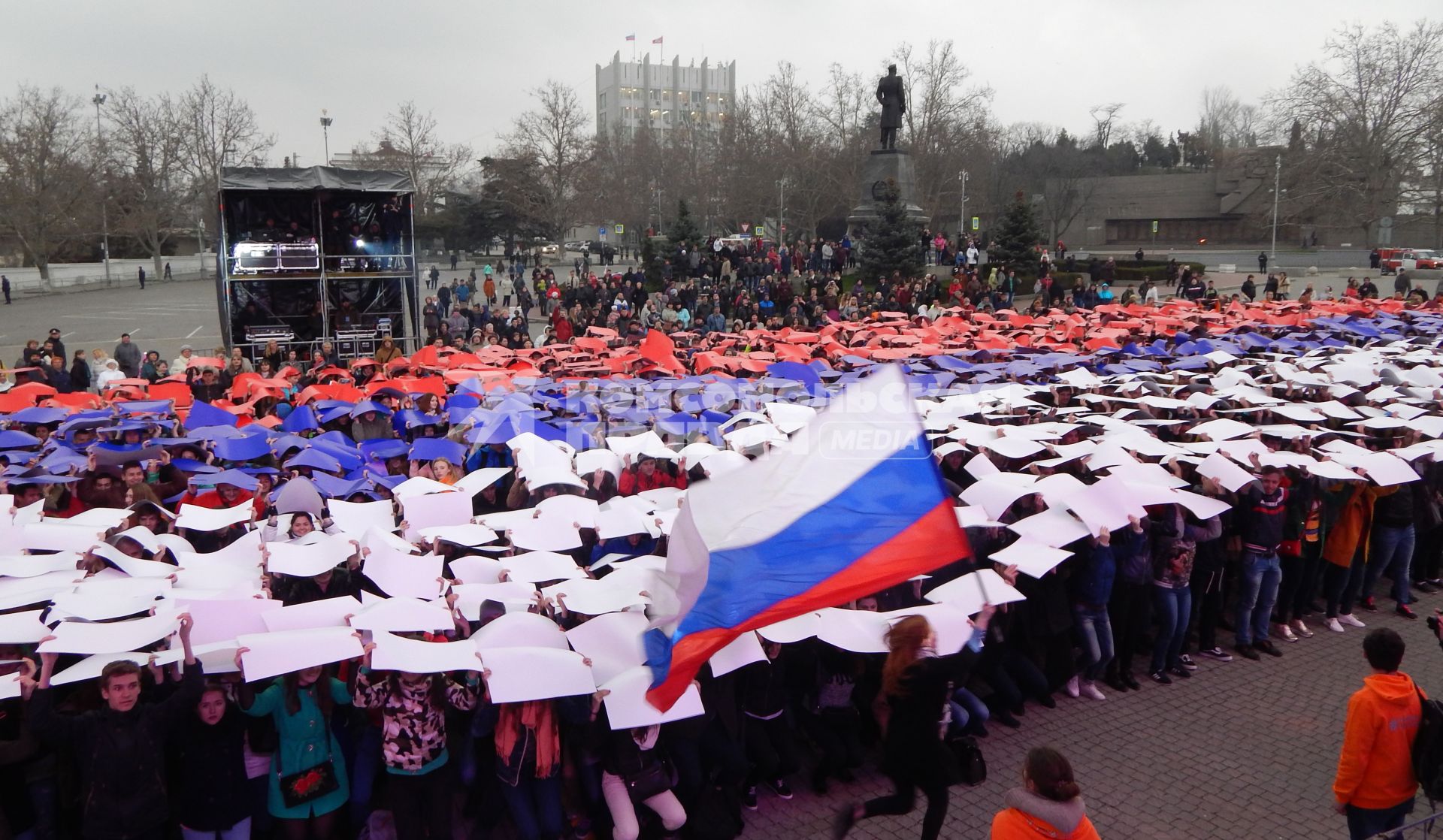 Севастополь. Участники флешмоба `Горжусь Россией!`, посвященного третьей годовщине воссоединения Крыма с Россией  выстроились в `живой` триколор на площади Нахимова.