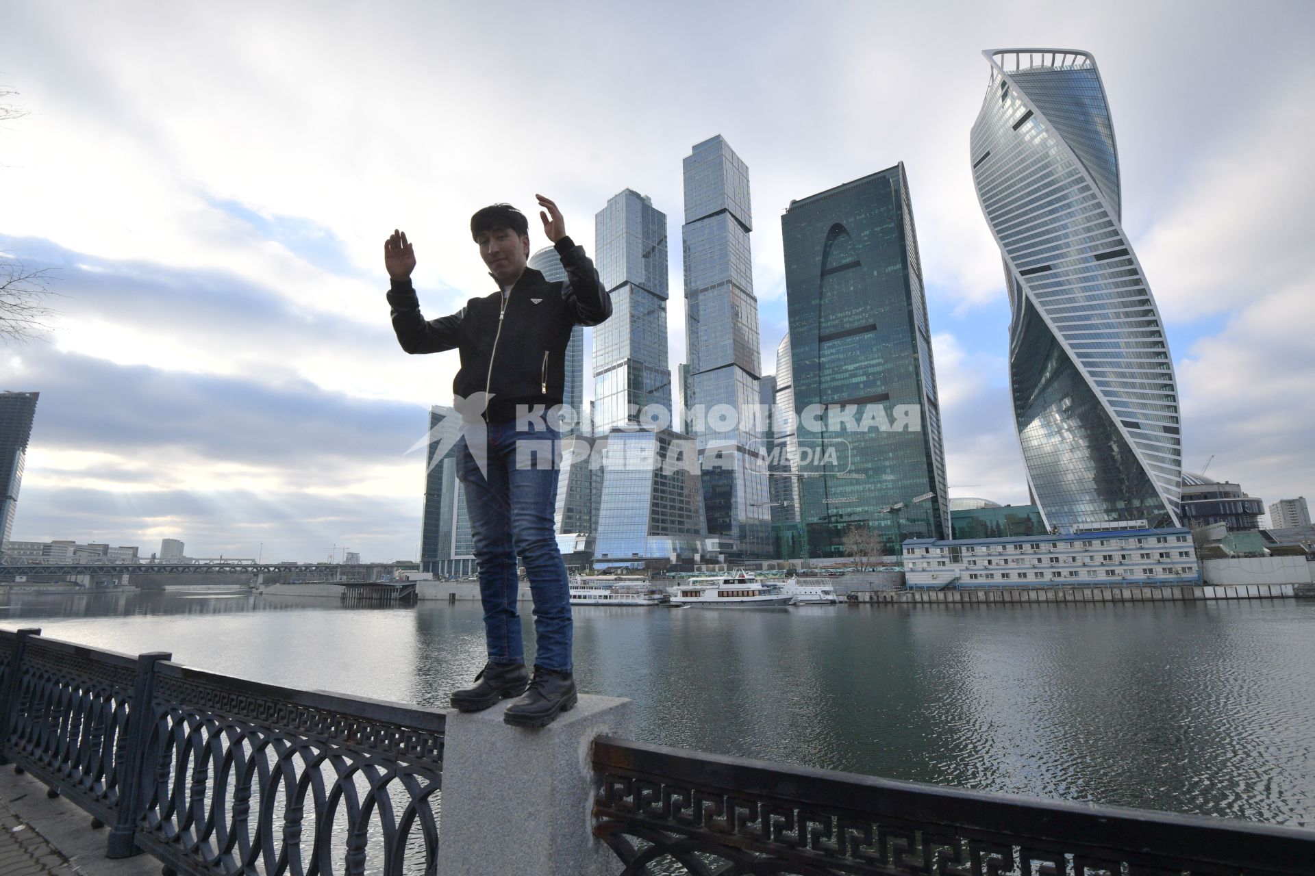 Москва.  Молодой человек позирует на фоне Делового центра  Москва-Сити  на набережной Тараса Шевченко.