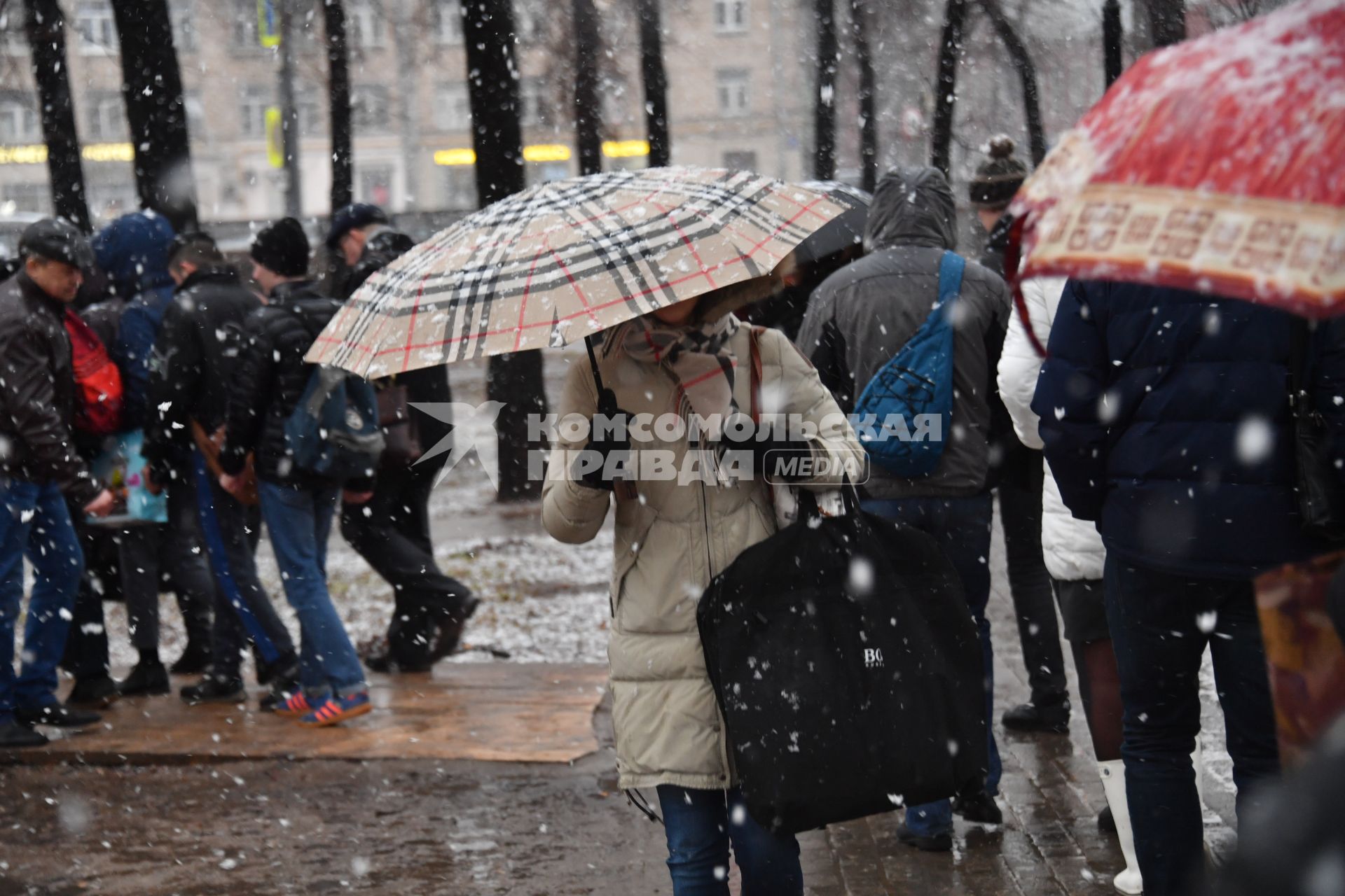 Москва. Люди идут по парку в снегопад.