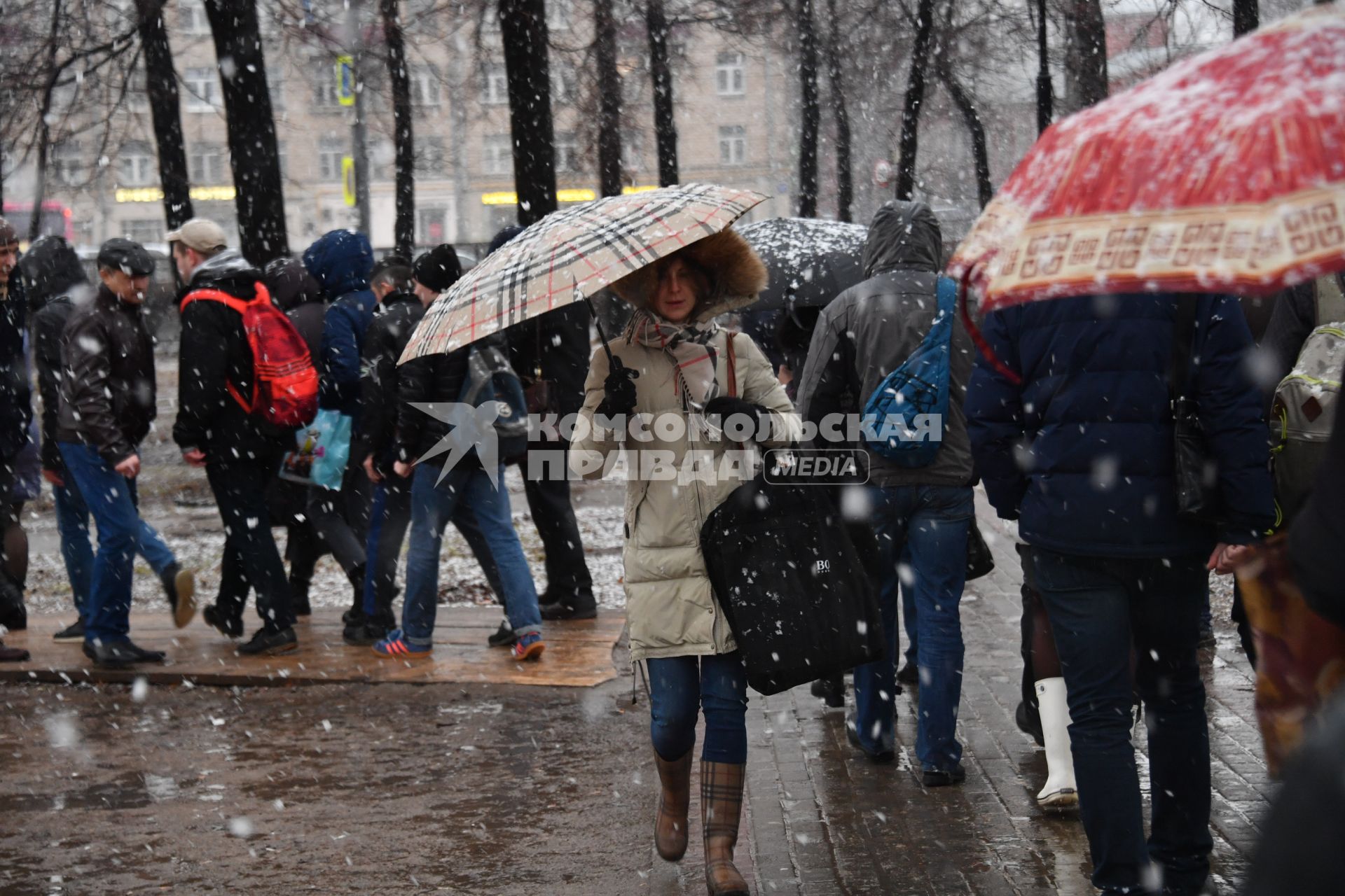 Москва. Люди идут по парку в снегопад.