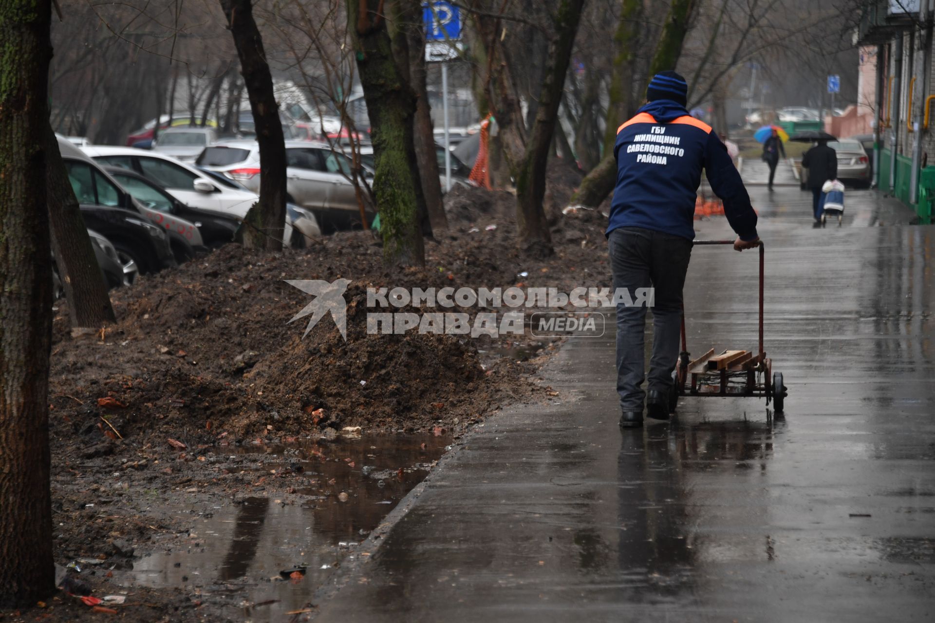 Москва. Дворник с тележкой на улице города.