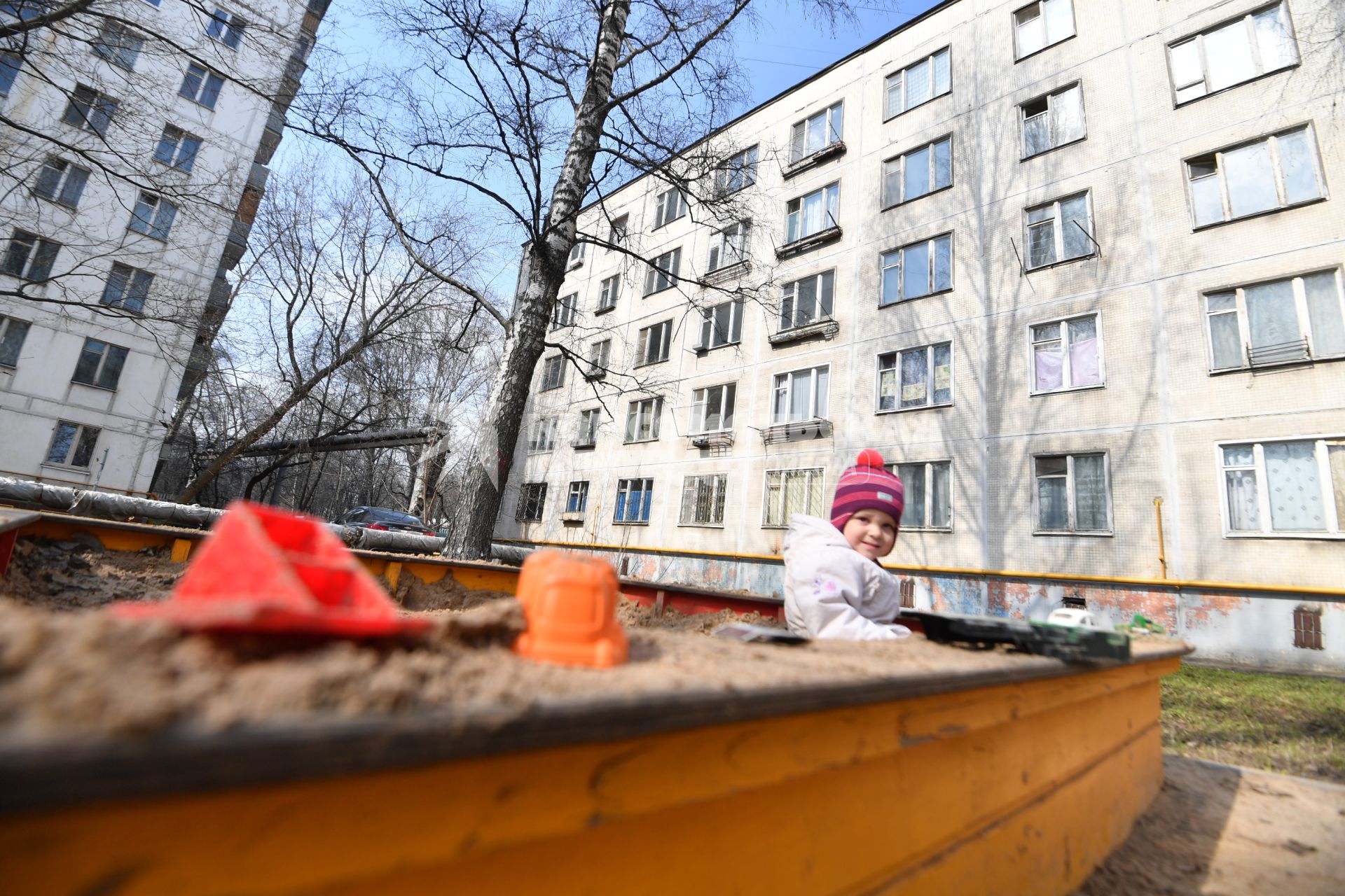 Москва. Ребенок играет в песочнице пятиэтажного дома на Полярной улице.