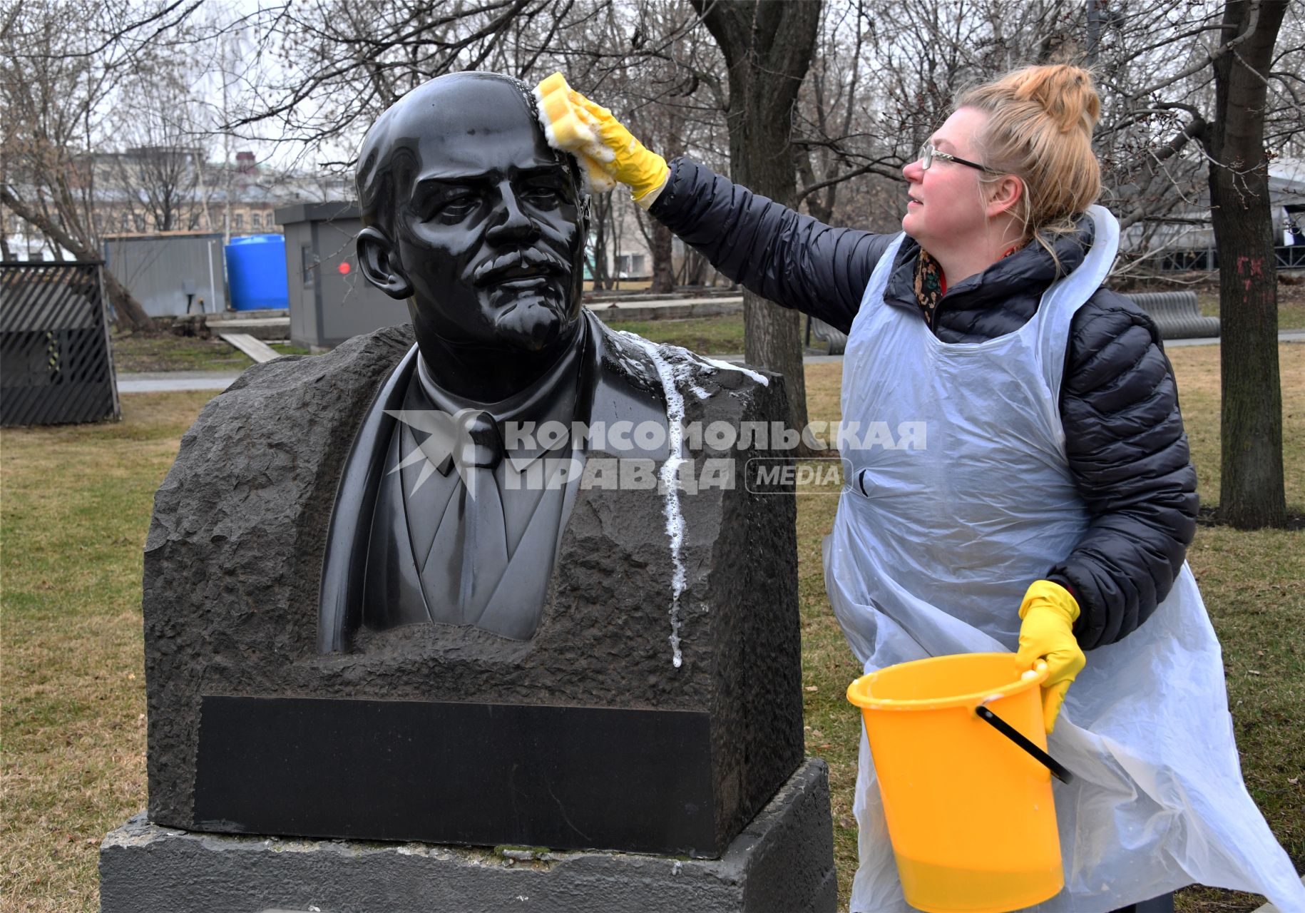 Москва. Участница общегородского субботника `За чистоту икусства` в парке  `Музеон` моет памятник Владимиру Ленину.