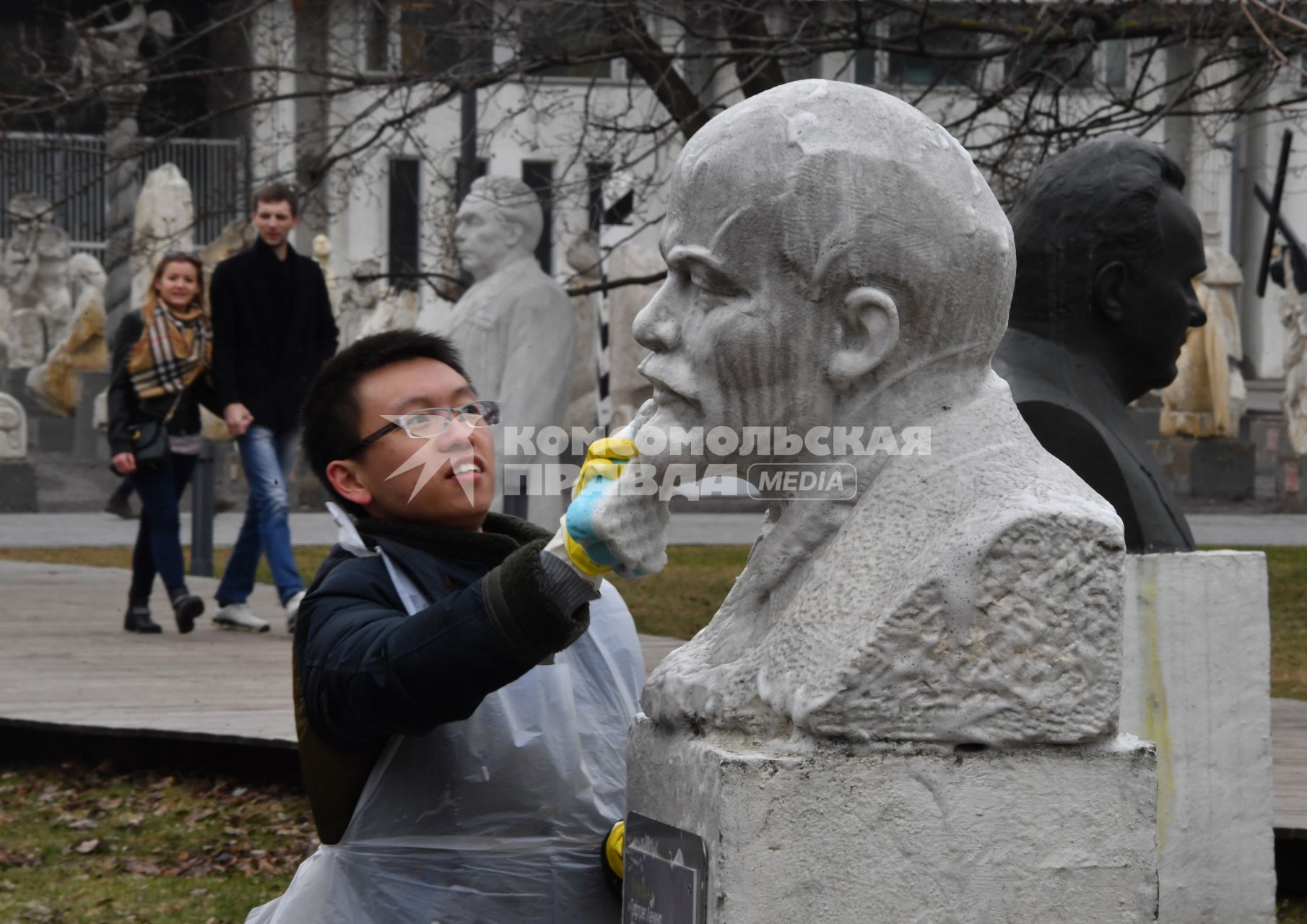 Москва. Молодой человек на общегородском субботнике `За чистоту икусства` в парке  `Музеон` моет памятник  Владимира Ленина.