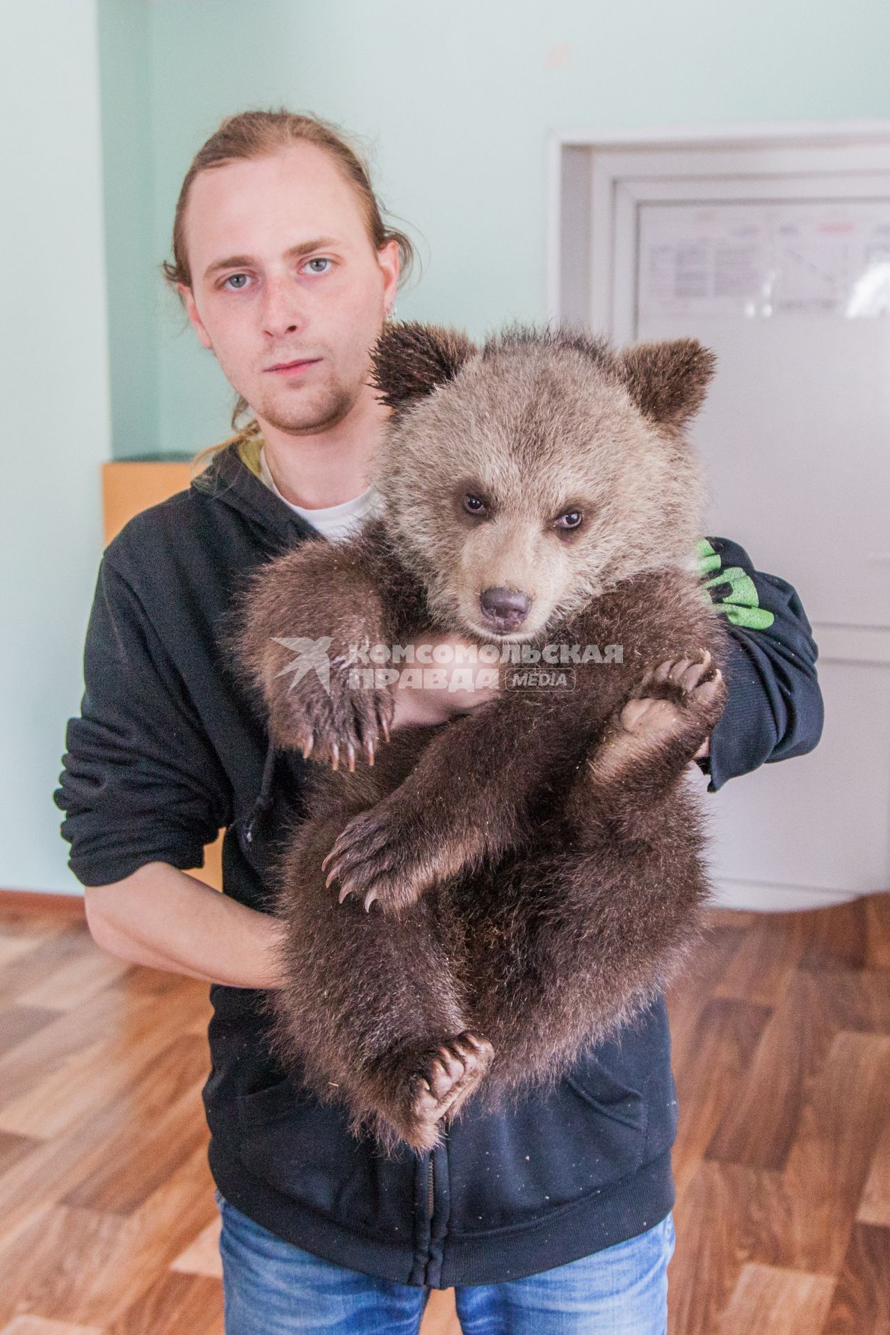 Уфа. Мужчина держит на руках бурого медвежонка,  родившегося  в вольере в парке Лесоводов.