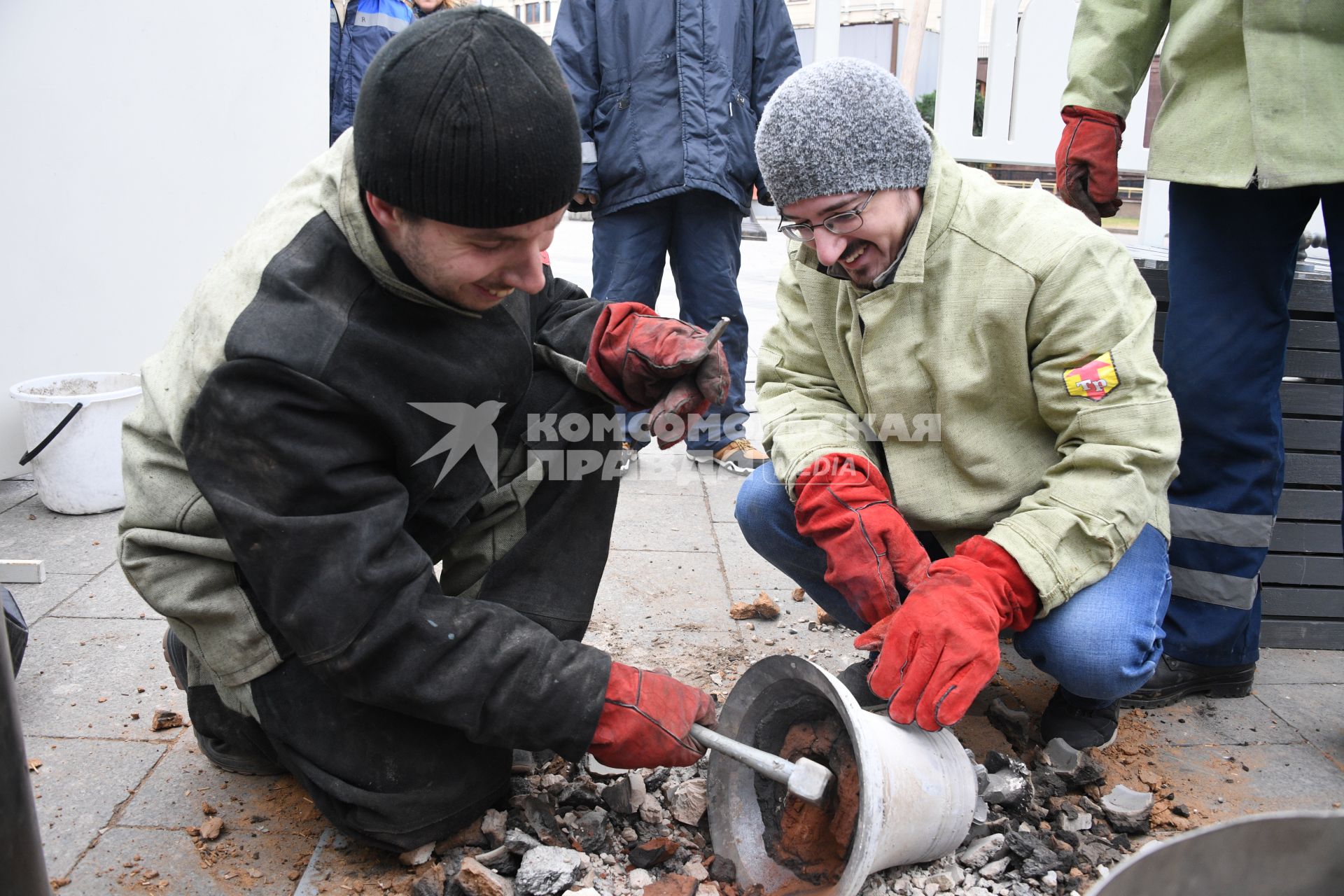 Москва.  Мастера-литейщики на площади Революции  в открытой литейной мастерской отливает колокол в рамках фестиваля `Пасхальный дар`.