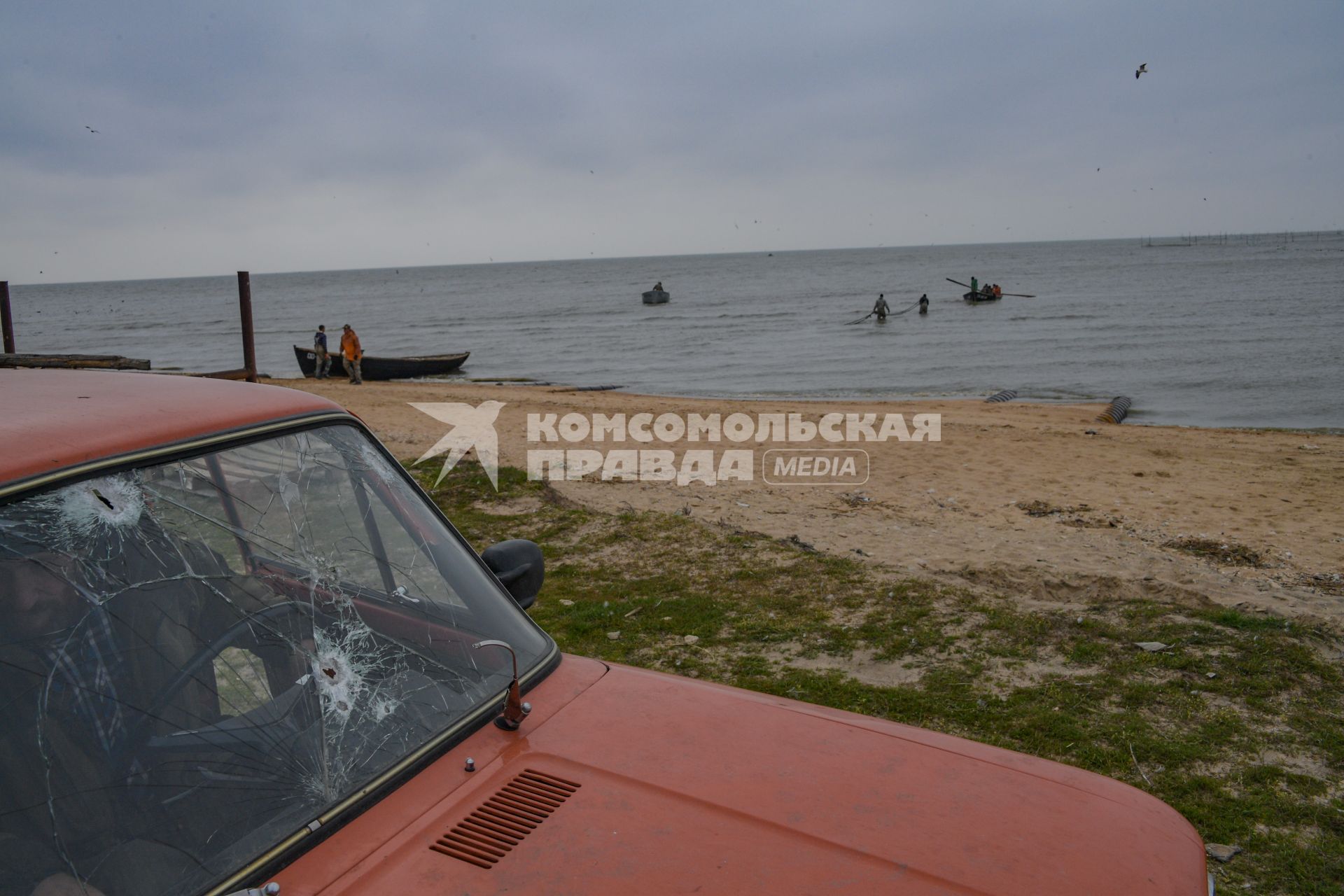 Украина, Новоазовский район , Безыменное.  Машина с пулевыми отверстиями на лобовом стекле  на берегу Таганрогского залива.