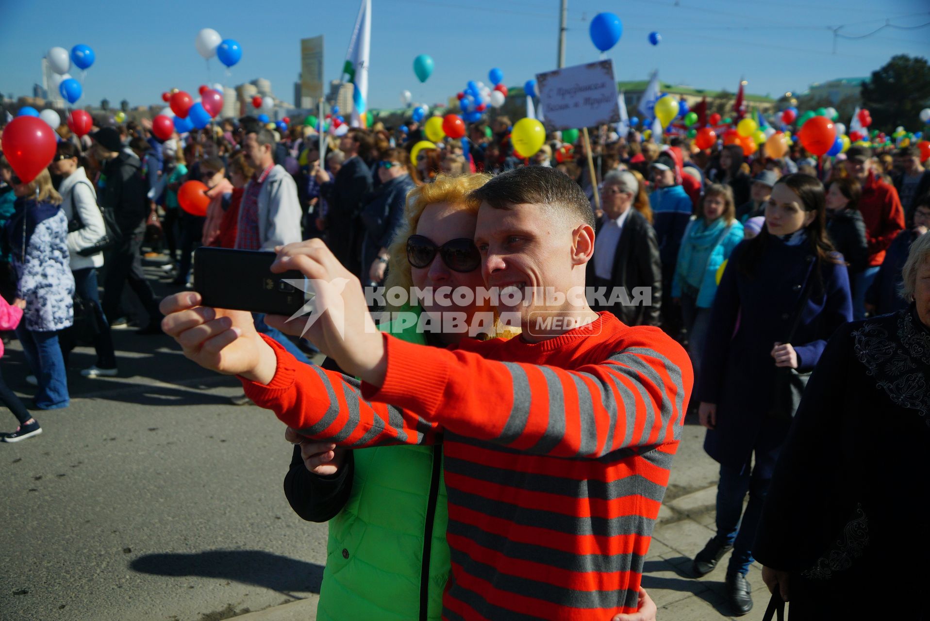 Екатеринбург. Участники первомайской демонстрации фотографируются на фоне шествия колонны профсоюзов в день весны и труда.