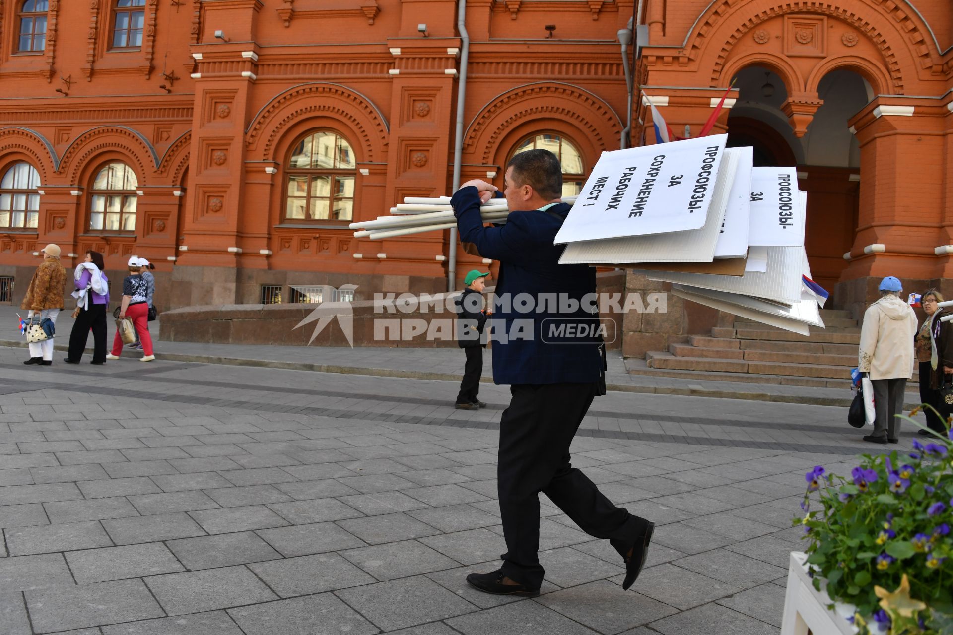 Москва. Мужчина несет плакаты после певомайской демонстрации.