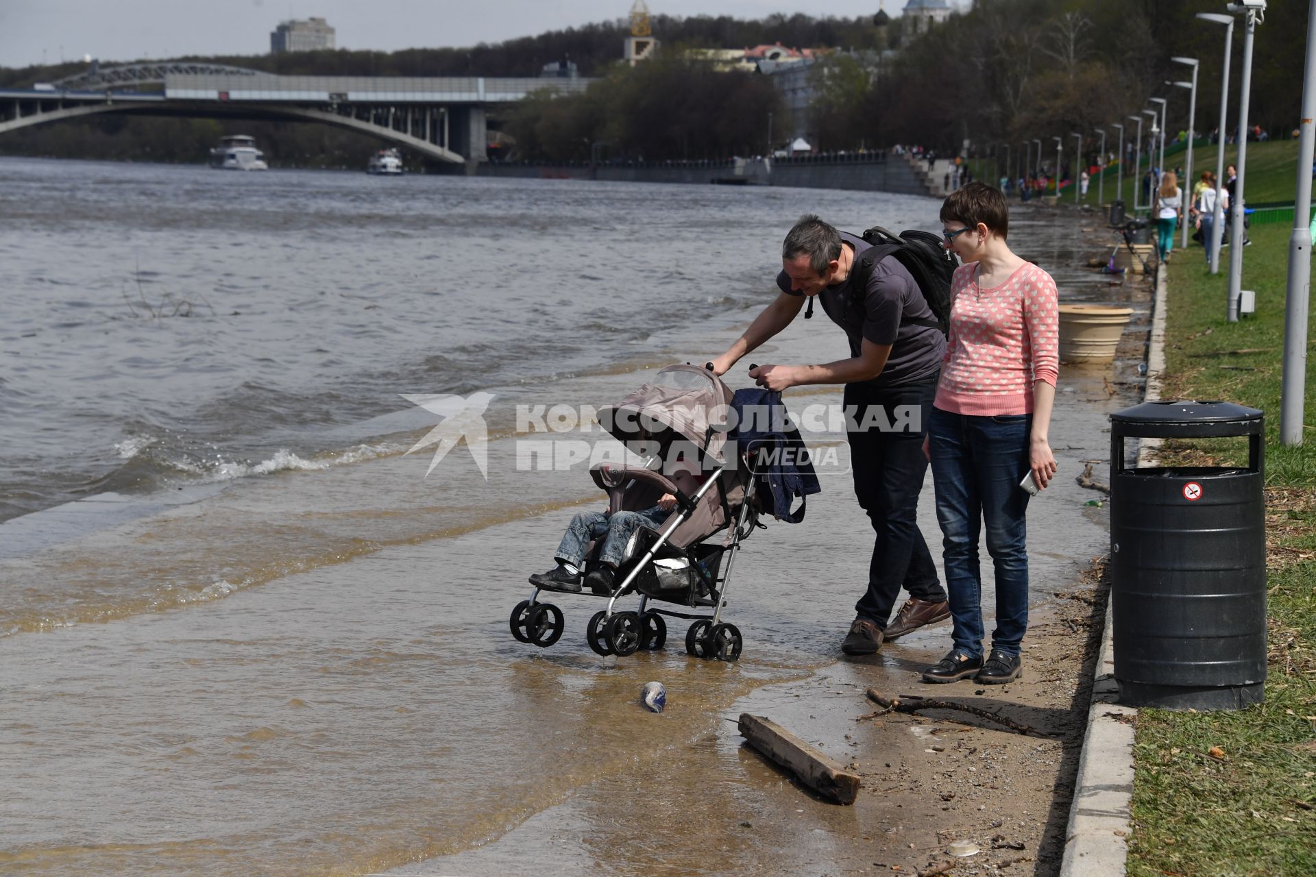 Москва. Семья с ребенком в коляске  гуляет по  затопленной   набережной  на Воробьевых горах.