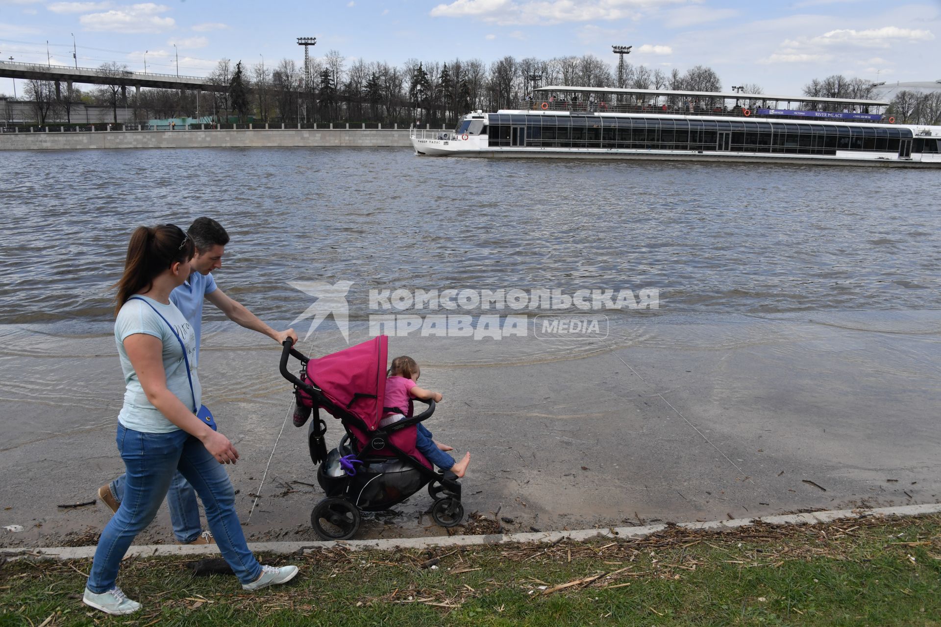 Москва. Семья с ребенком в коляске  гуляет по  затопленной   набережной  на Воробьевых горах.