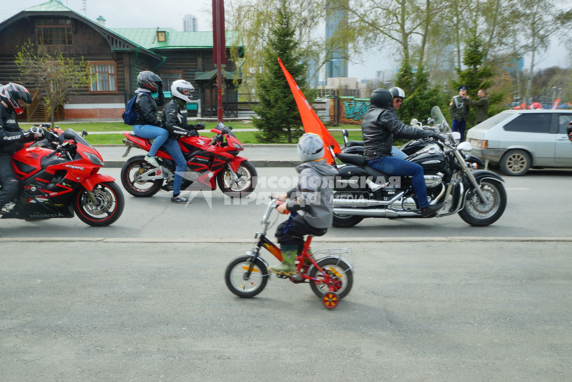 Екатеринбург. Ребенок на велосипеде едет мимо колонны мотоциклистов во время открытия мотосезона