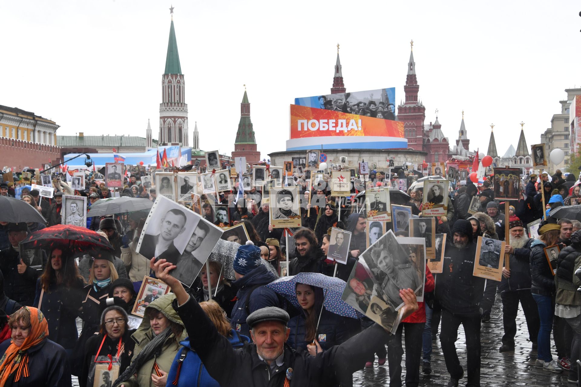 Москва.  Участники акции памяти  `Бессмертный полк` во время шествия в День Победы на Красной площади.