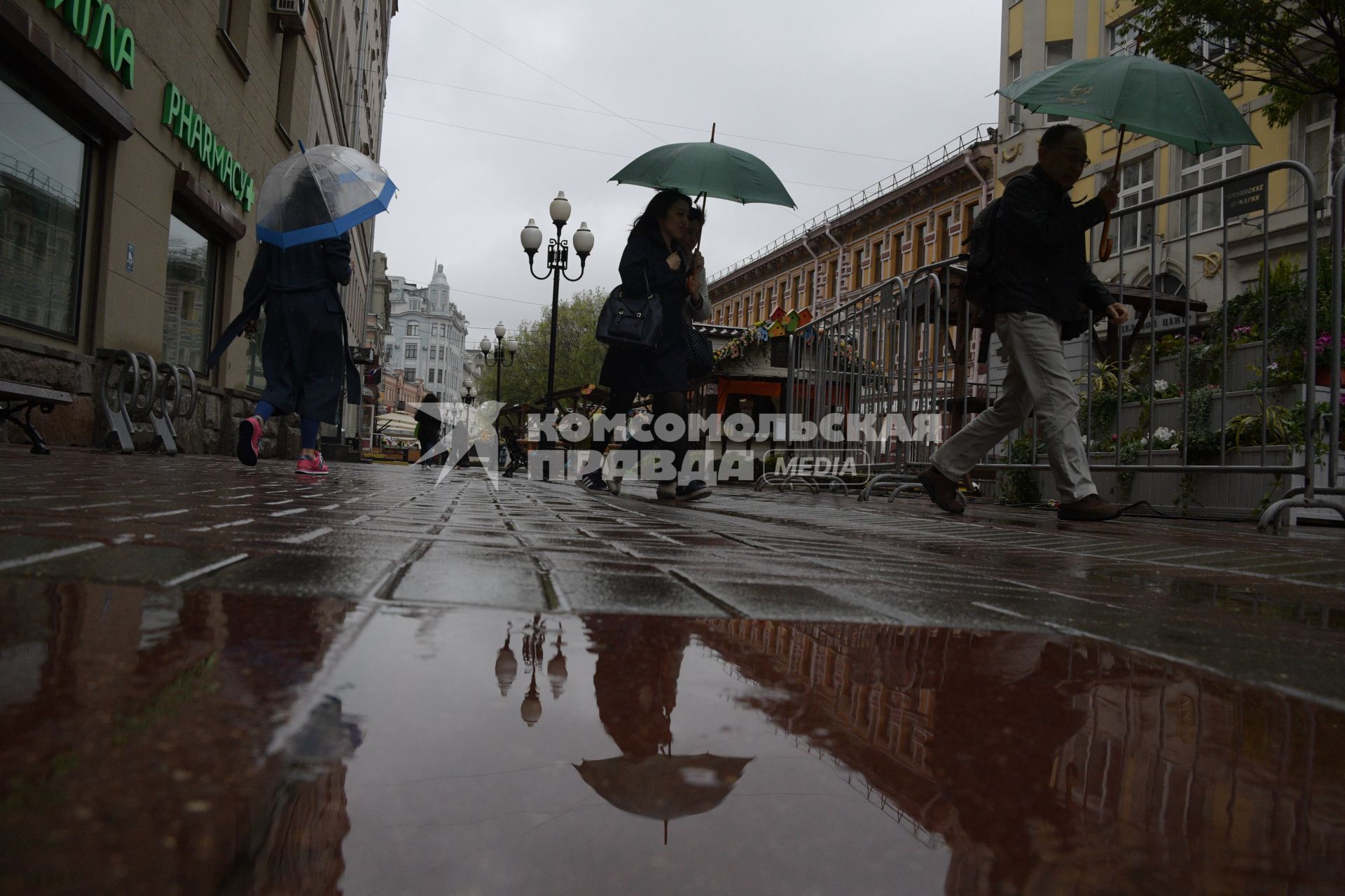 Москва.  Прохожие под дождем идут по Старому Арбату.