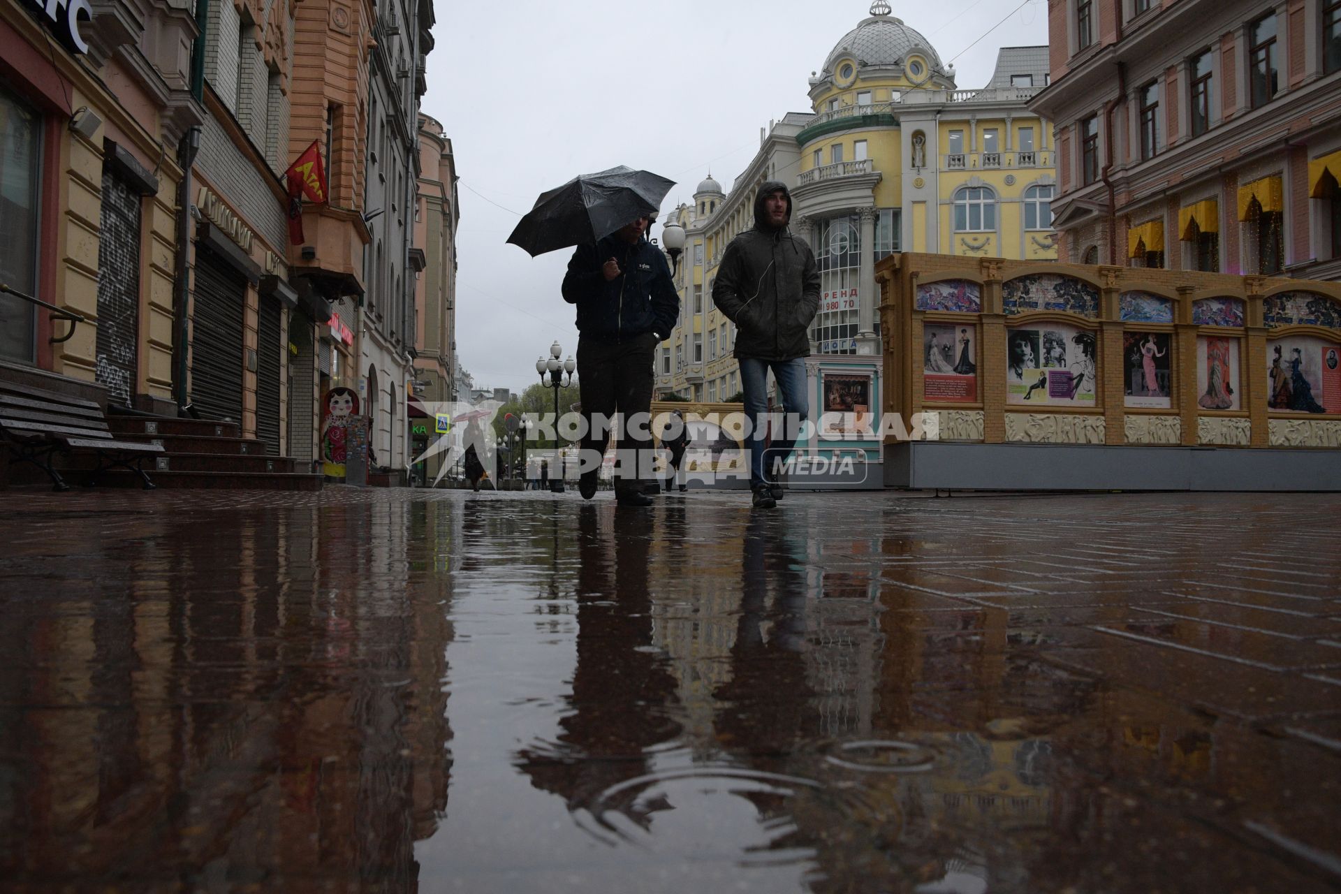 Москва.  Прохожие под дождем идут по Старому Арбату.