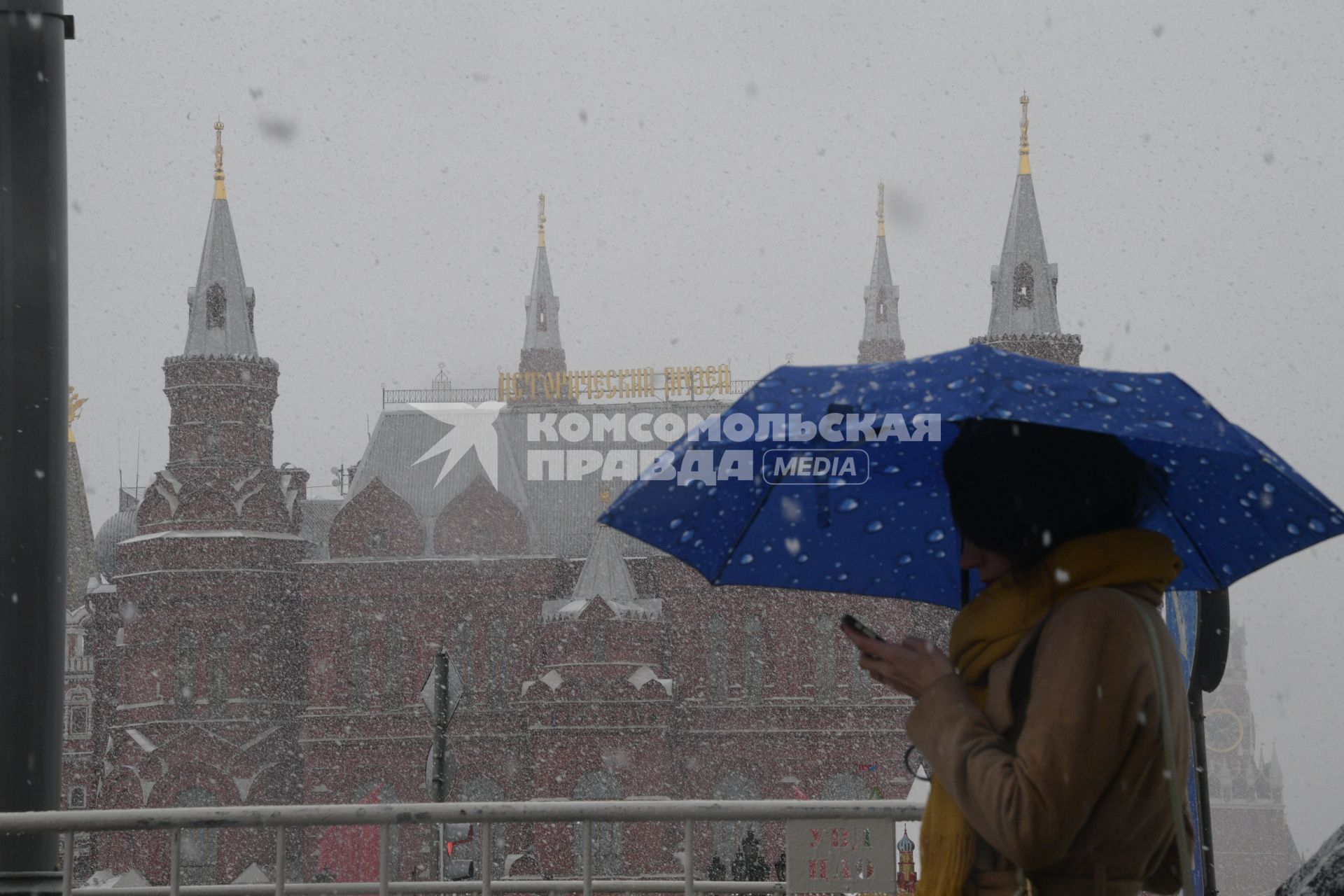 Москва.   Женщина под зонтом на Манежной площади.