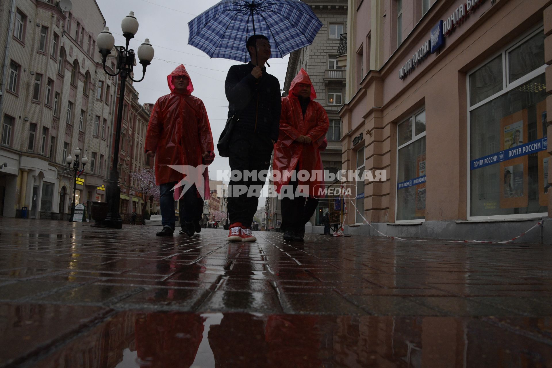 Москва.  Прохожие под дождем идут по Старому Арбату.