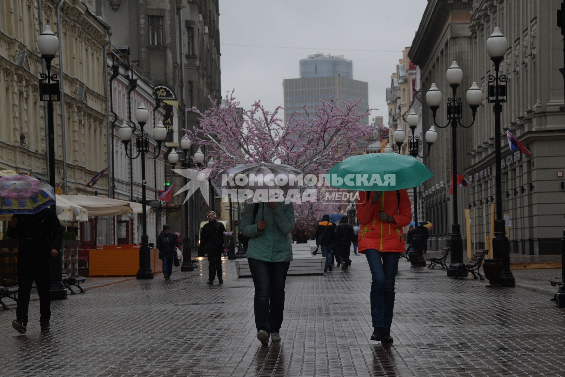 Москва.  Прохожие под дождем идут по Старому Арбату.