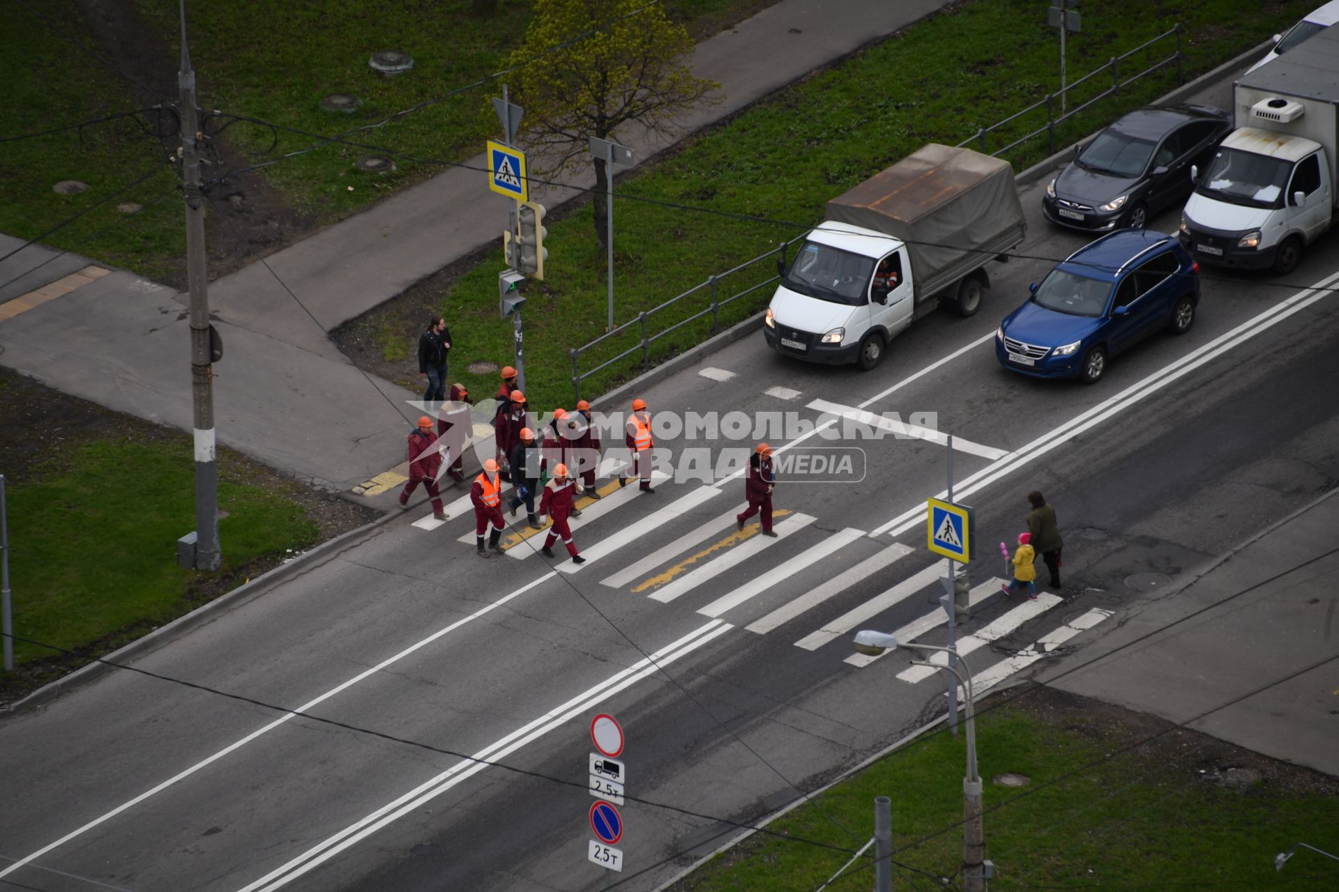 Москва.  Рабочие переходят дорогу по пешеходному переходу в районе Бескудниково.