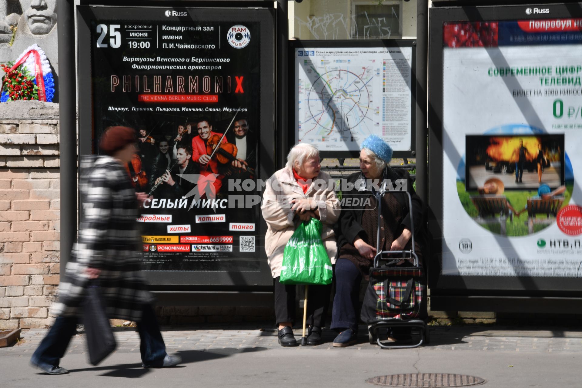 Москва. Бабушки сидят на остановке городского транспорта.