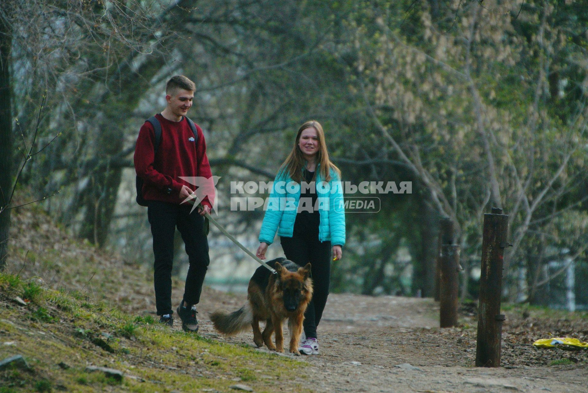 Екатеринбург. Парень и девушка гуляют с собакой породы овчарка