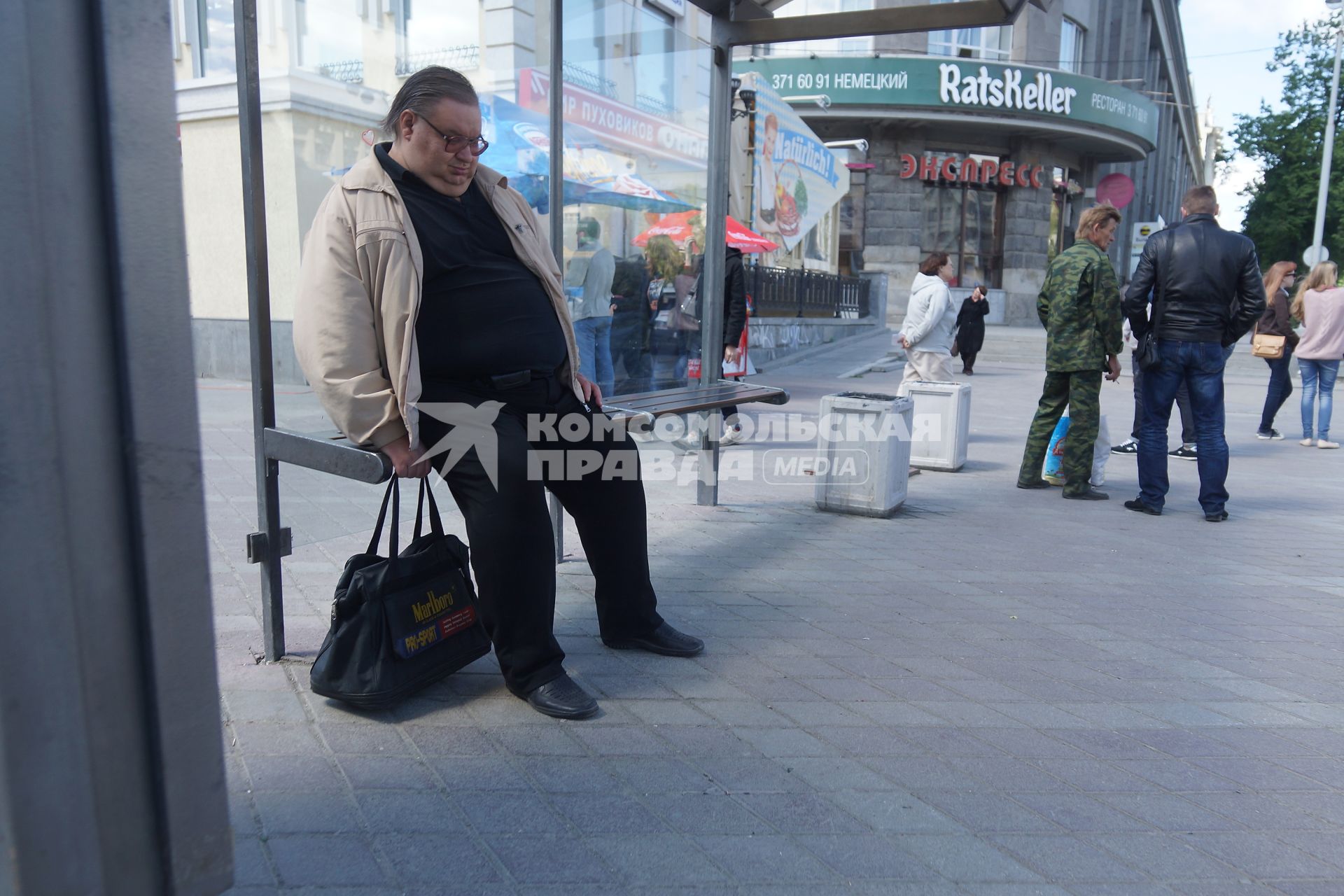 Екатеринбург. Мужчина с ожирением сидит на остановке общественного транспорта