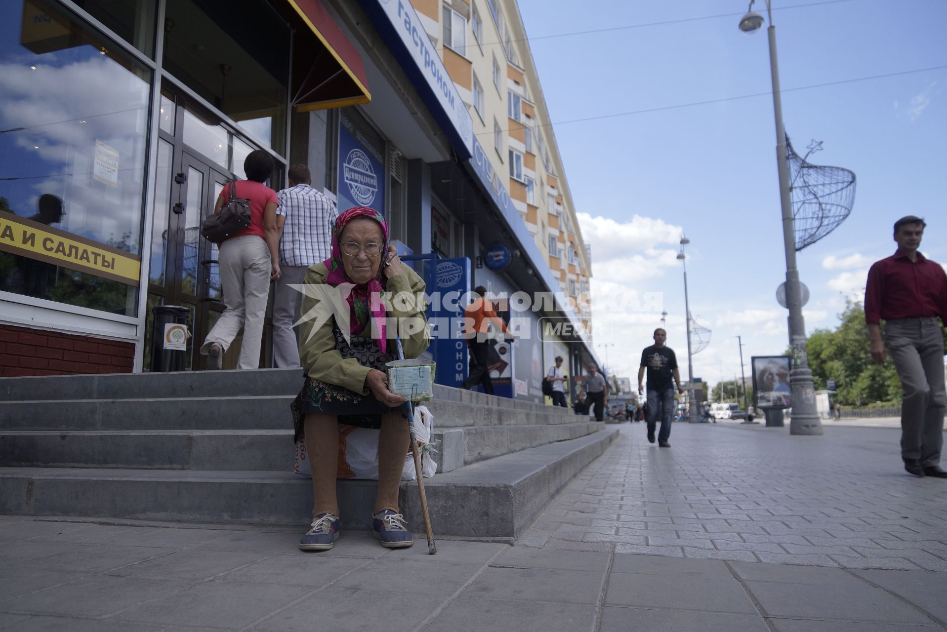 Екатеринбург. Старушка просит милостыню сидя на ступенях у магазина