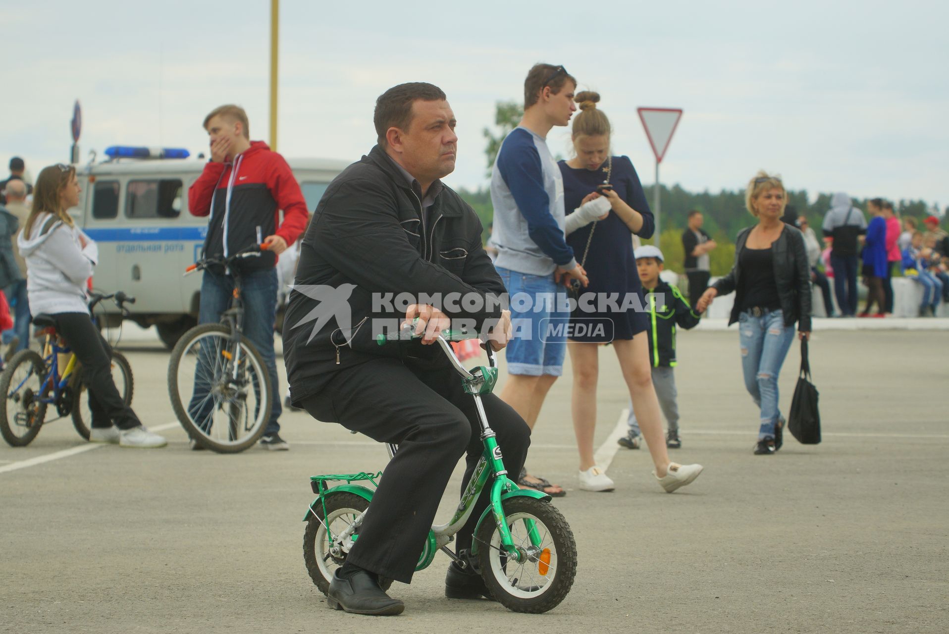 Екатеринбург.Мужчина сидит на маленьком детском велосипеде