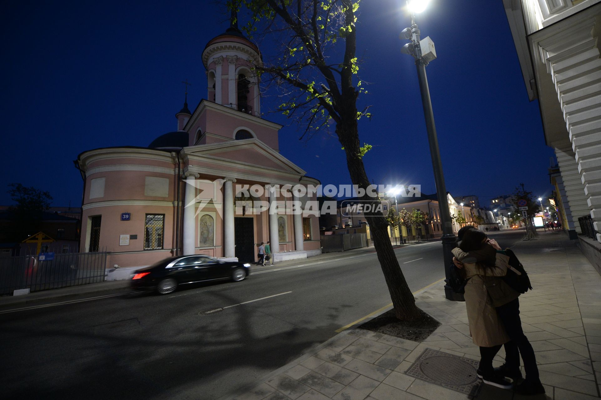 Москва.  Молодые люди целуются на улице Большая Ордынка .