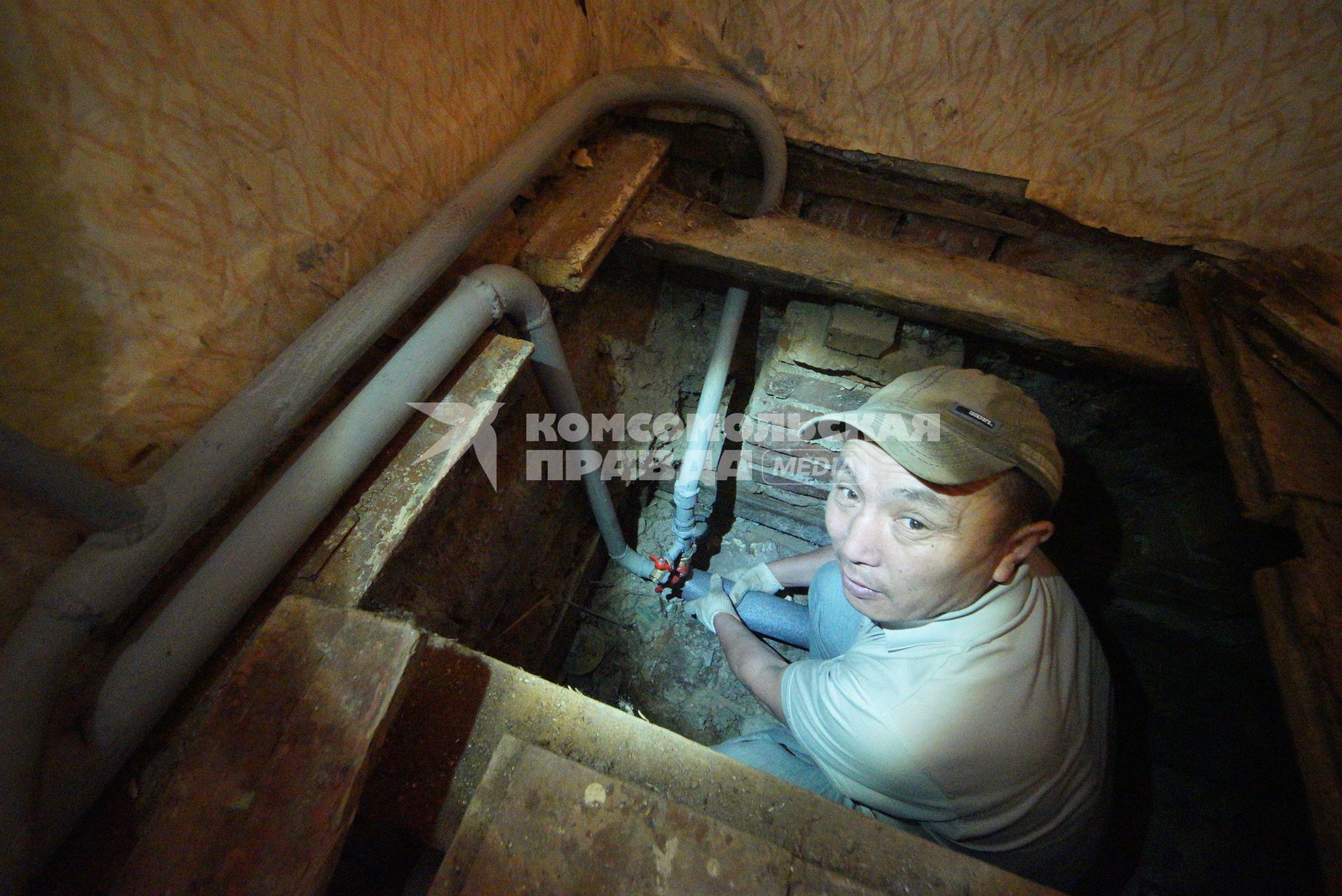 Екатеринбург. Рабочий-сантехник меняет трубы водопроводные трубы во время капитального ремонта многоквартирного жилого дома