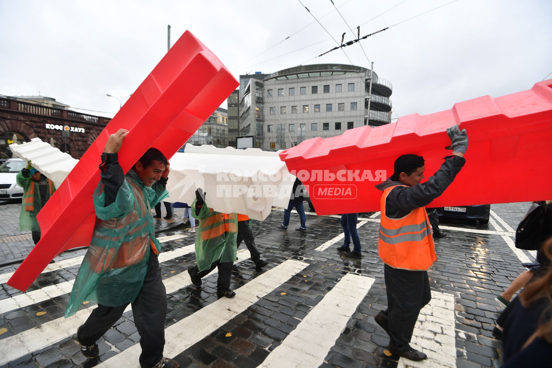 Москва. Гастарбайтеры несут пластиковые дорожные барьеры во время ремонта дороги у метро `Баррикадная`.