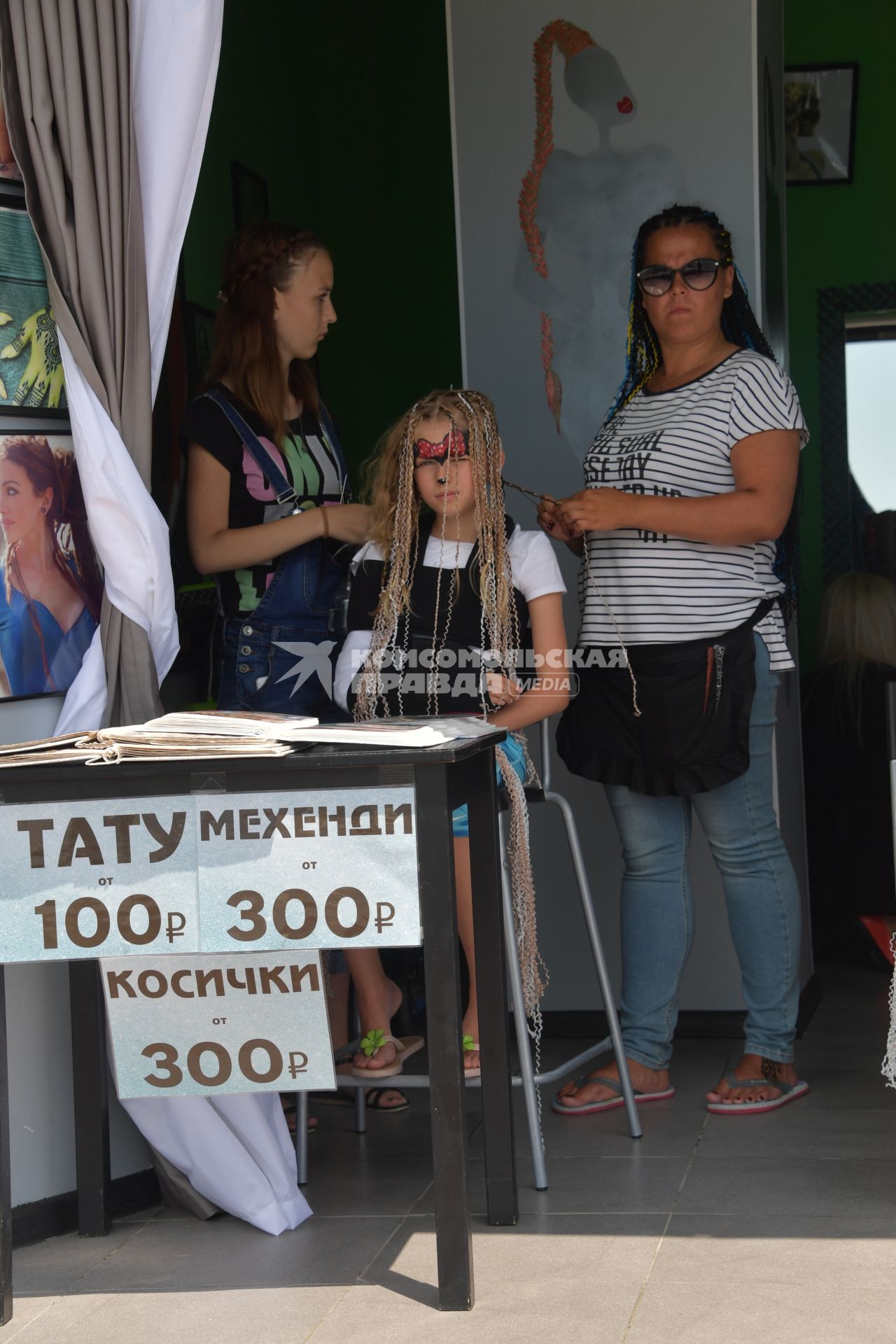 Сочи. Девушки  делают девочке прическу в  салоне.