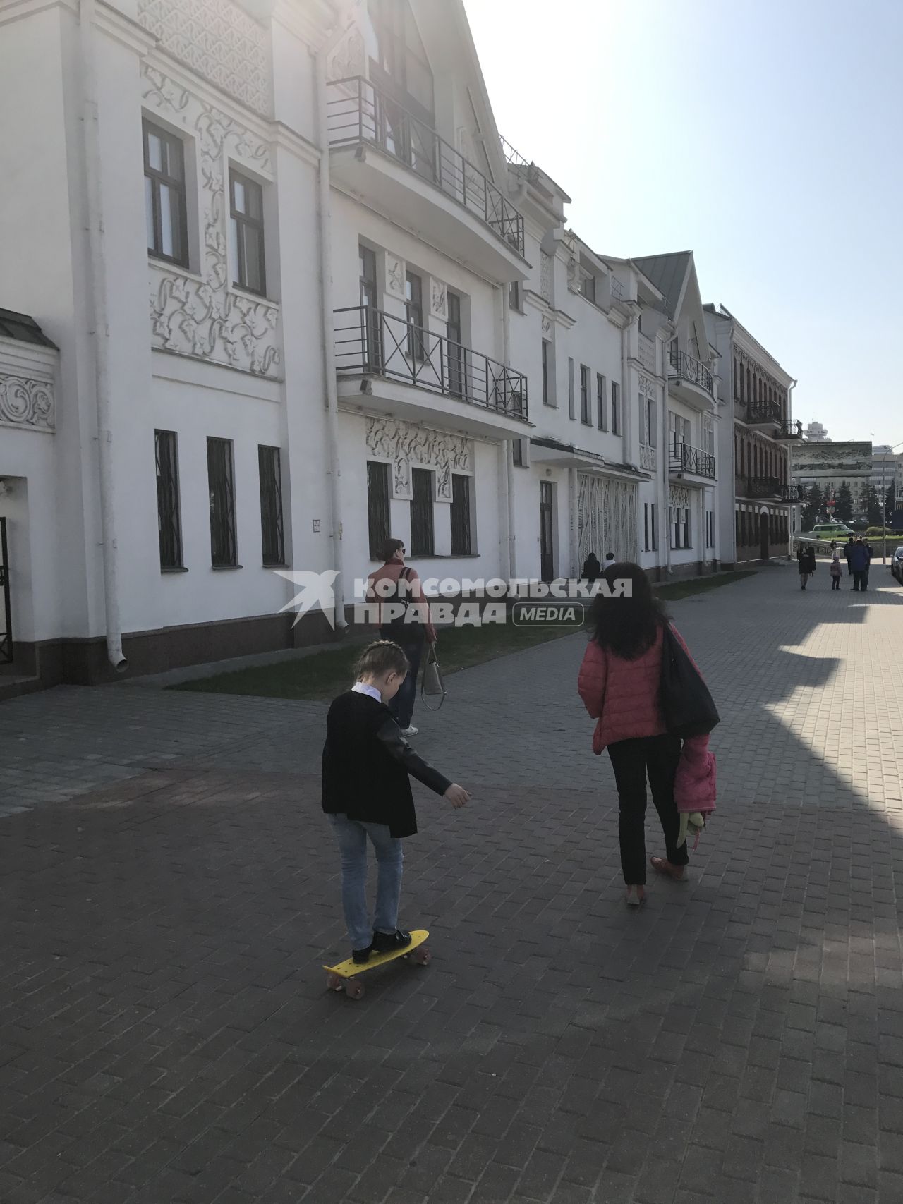 Белоруссия. Минск.  Девочка катается на скейтборде на одной из городских улиц.