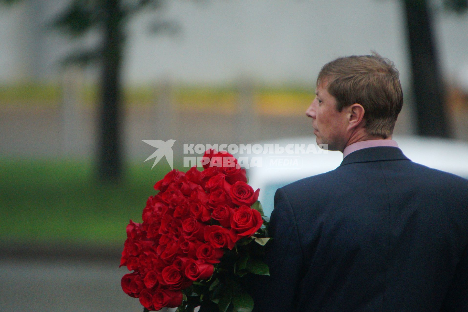 Екатеринбург. Мужчина в деловом костюме с букетом красных роз