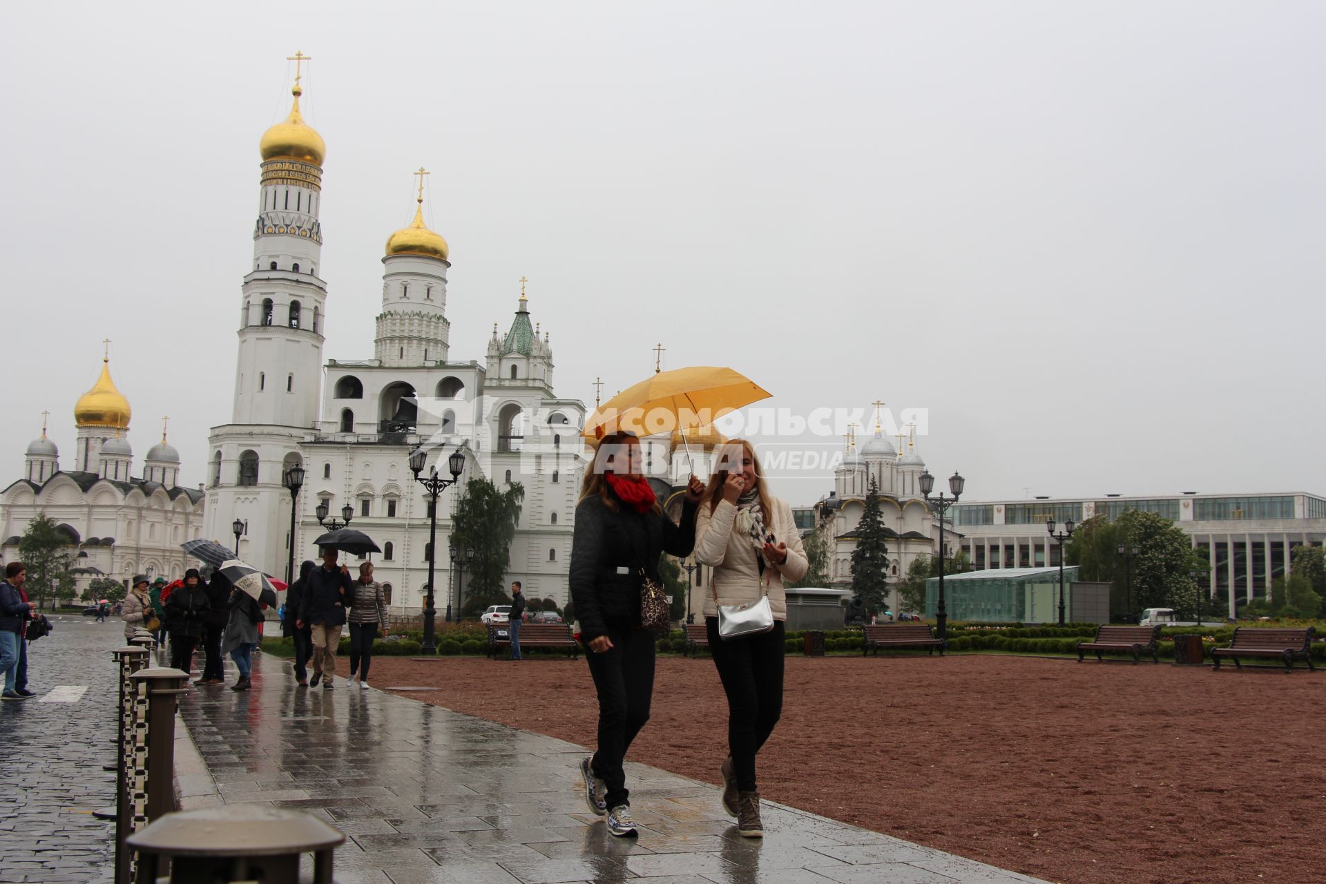 Москва. Туристы под зонтами на Ивановской площади  в Кремле.