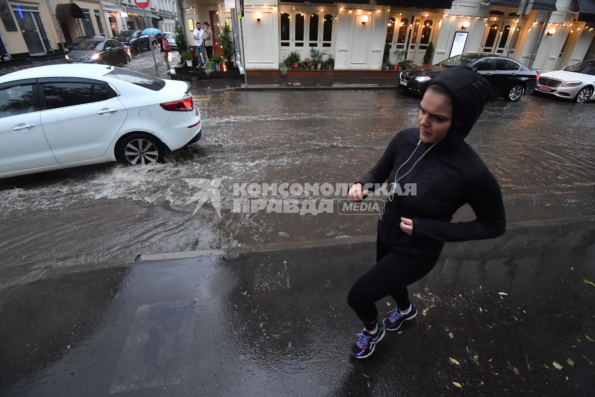 Москва. Девушка совершает пробежку по Малой Бронной во время дождя.