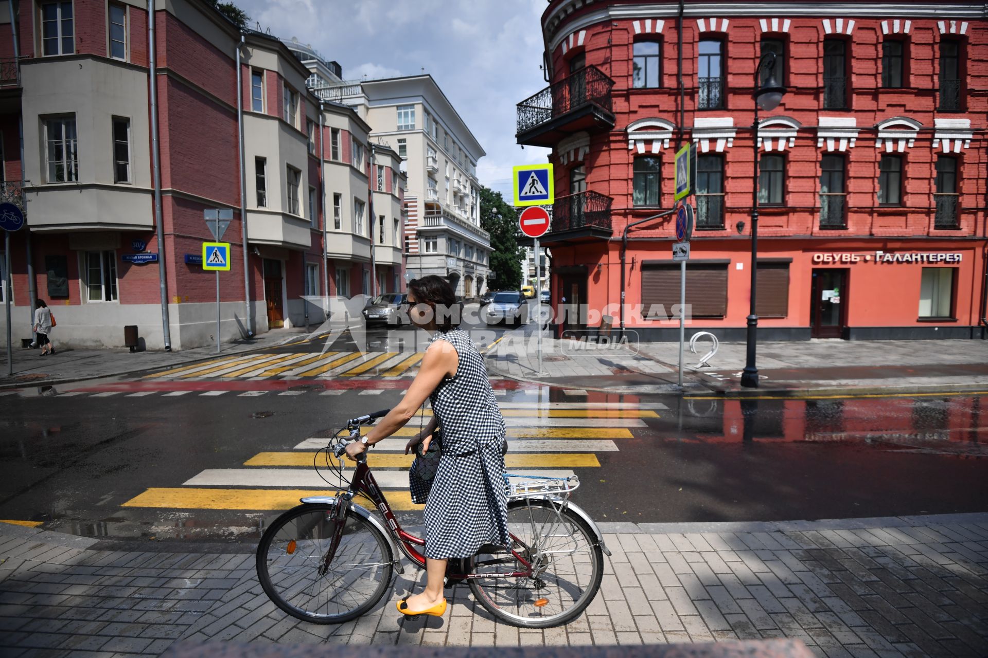 Москва. Девушка  едет на велосипеде по Малой Бронной.