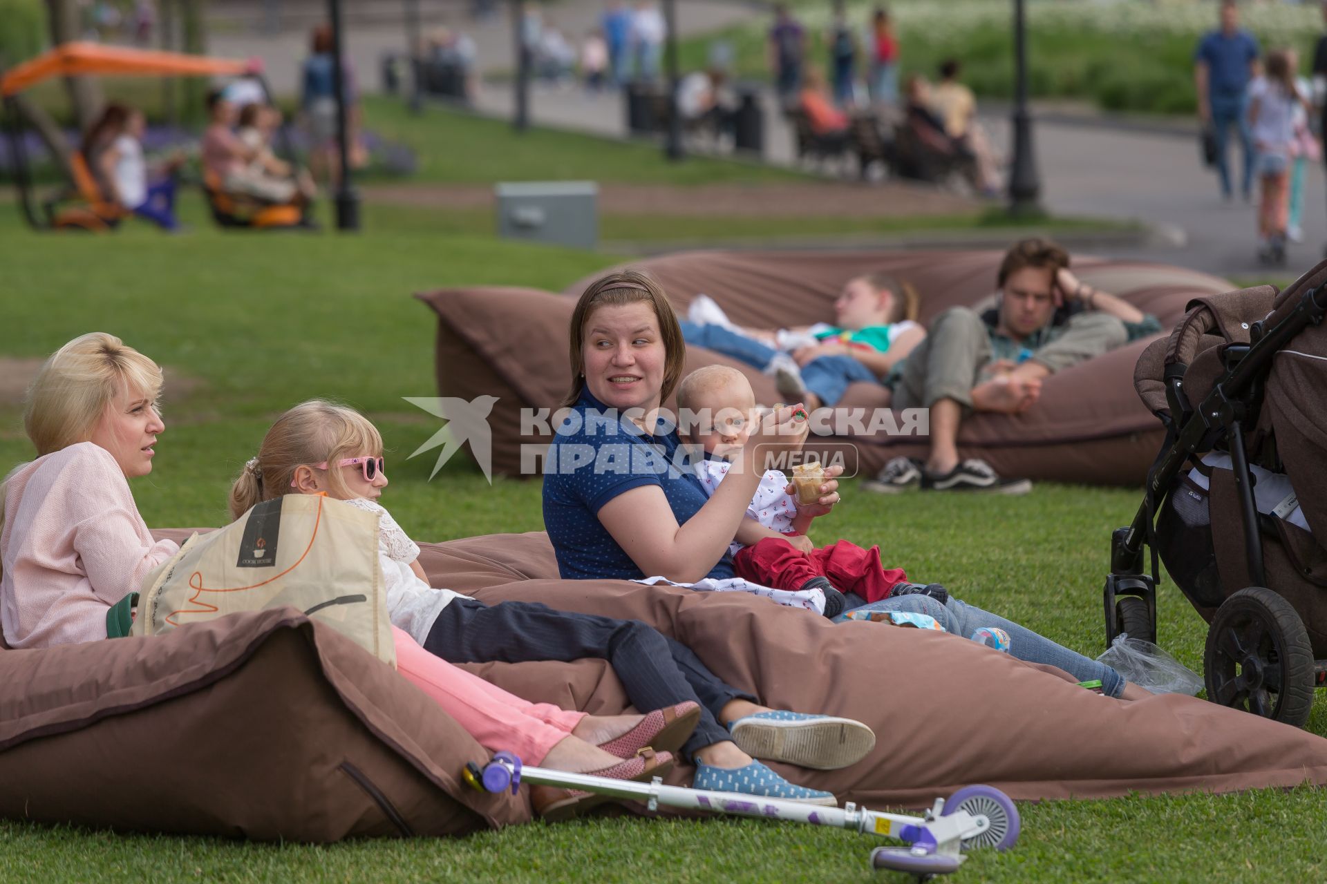 Москва. Женщина с ребенком на газоне в парке.