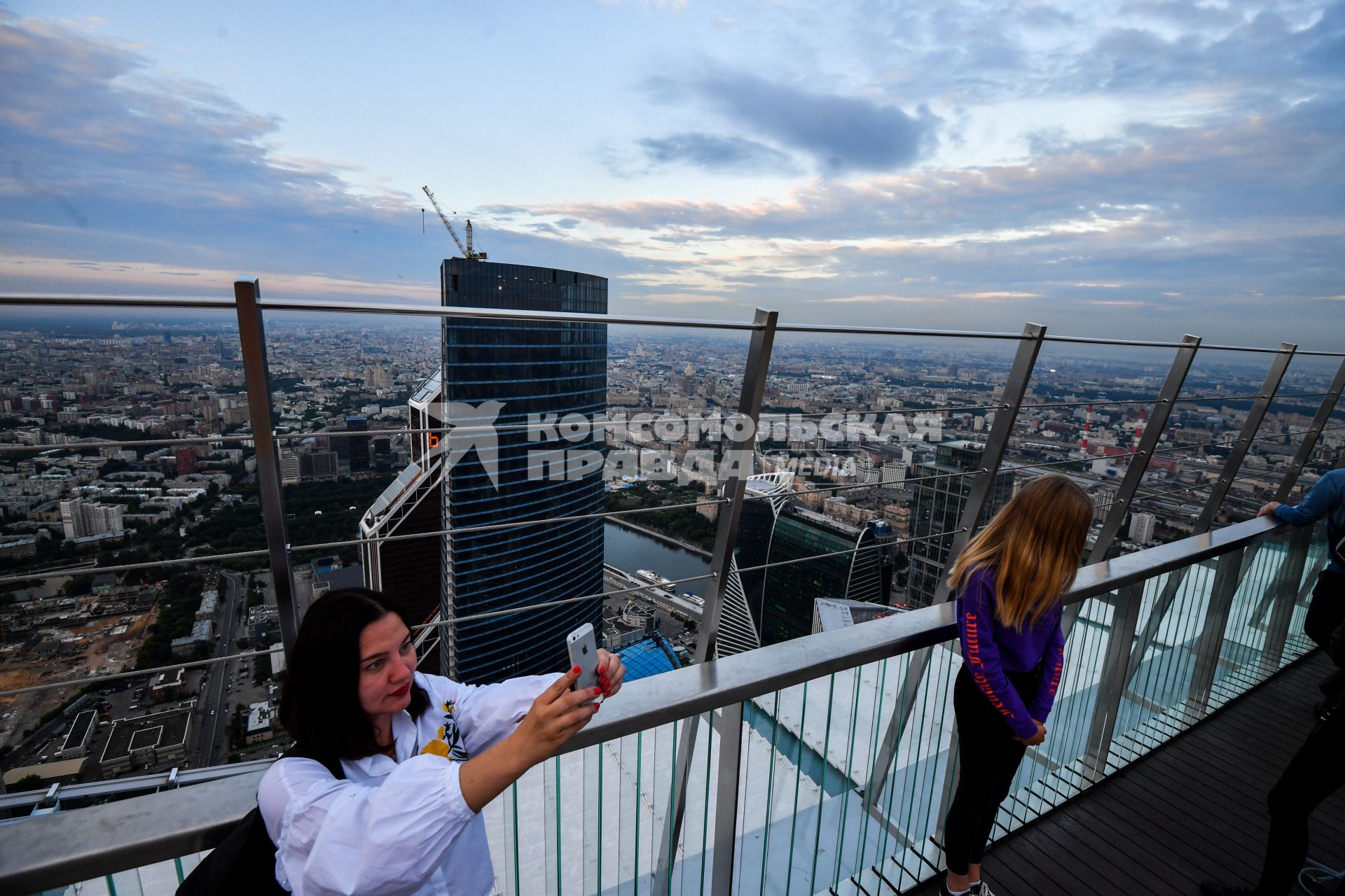 Москва.  Девушки делают селфи  на смотровой площадке башни `Око` делового центра   ` Москва -Сити`.