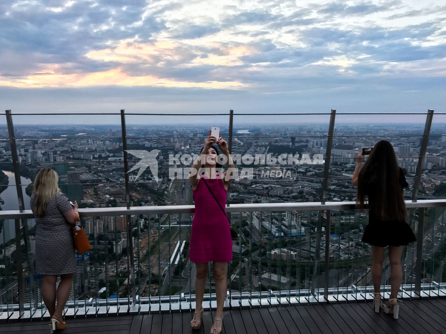 Москва.  Девушки делают селфи  на смотровой площадке башни `Око` делового центра   ` Москва -Сити`.