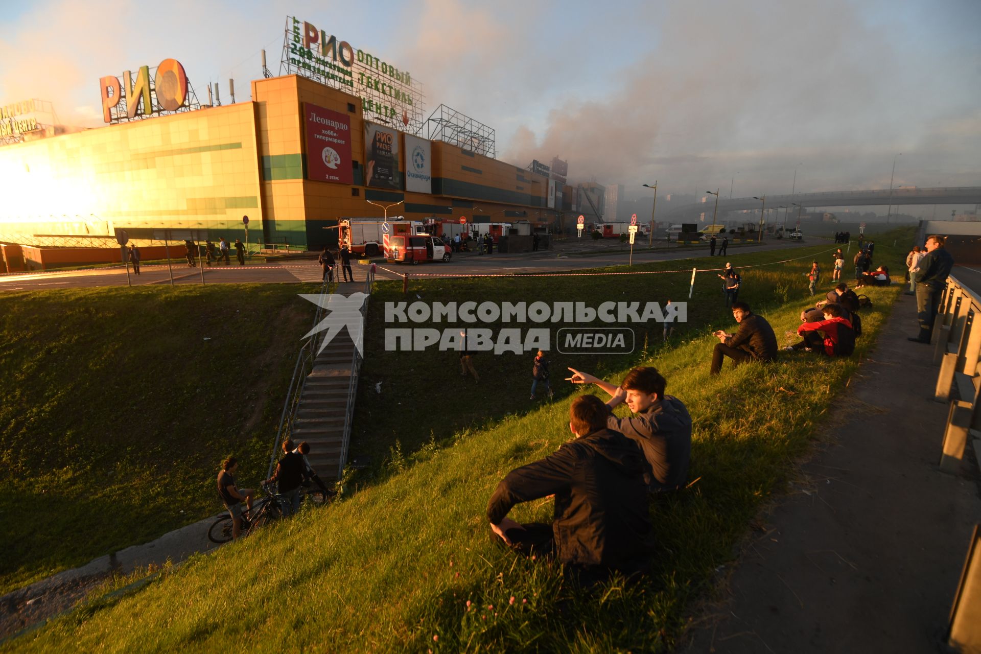 Москва.  Прохожие наблюдают за тушением пожара  в здании торгового центра `РИО` на Дмитровском шоссе.