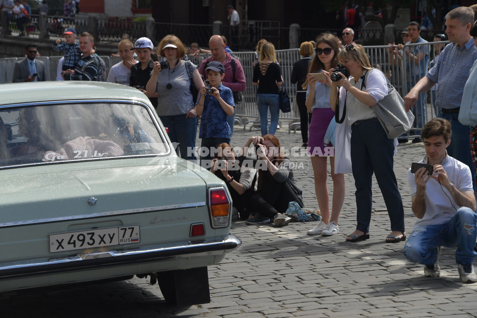 Москва. Зрители фотографируют участников  ГУМ-авторалли Gorkyclassic-2017 перед стартом .